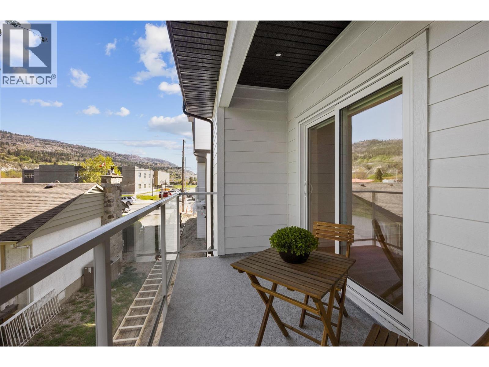 Representative listing media for Unit 101 at 143 Green Avenue, Penticton — covered balcony with mountain outlook