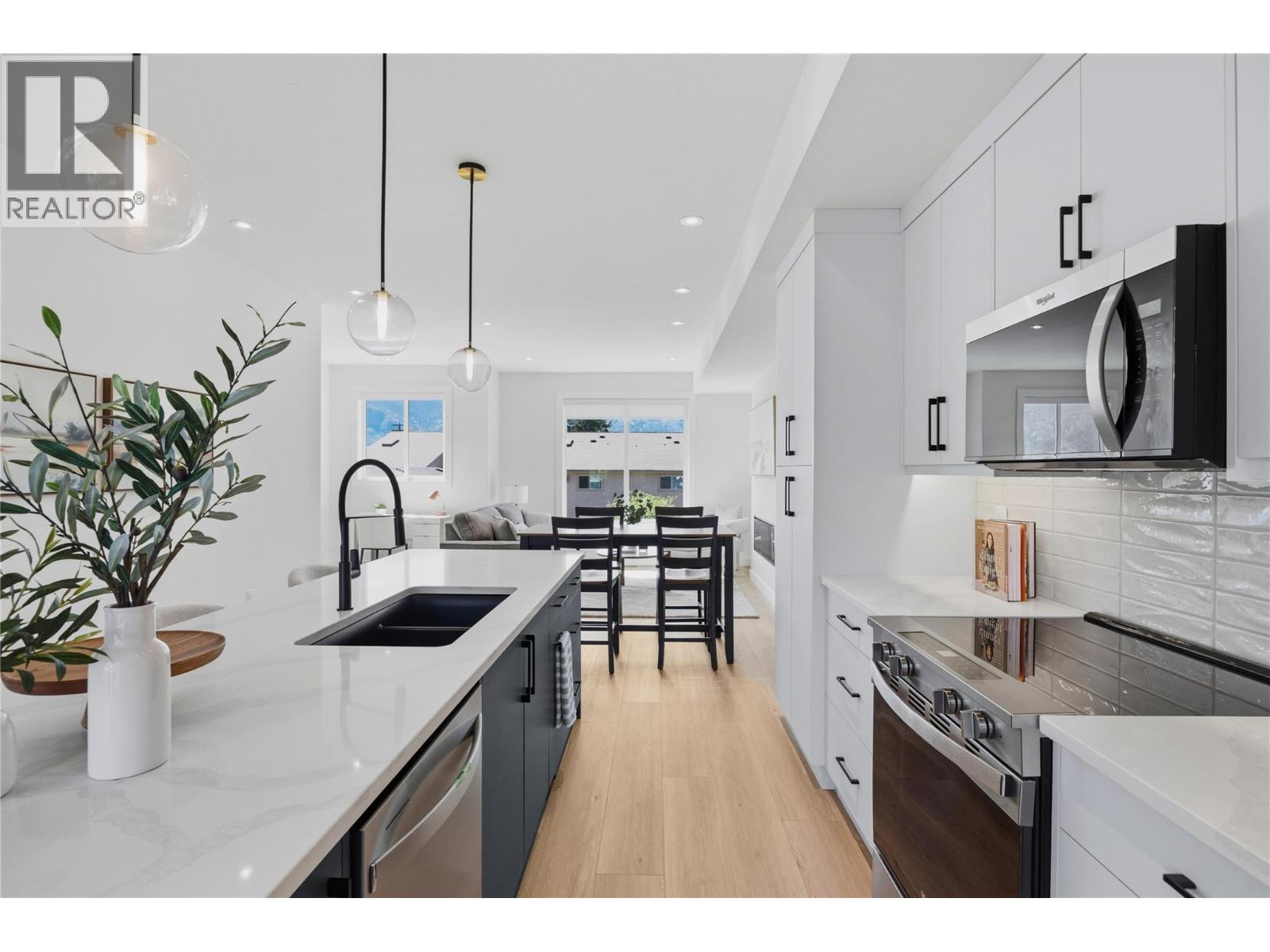 Representative listing media for Unit 102 at 143 Green Avenue, Penticton — quartz-island kitchen