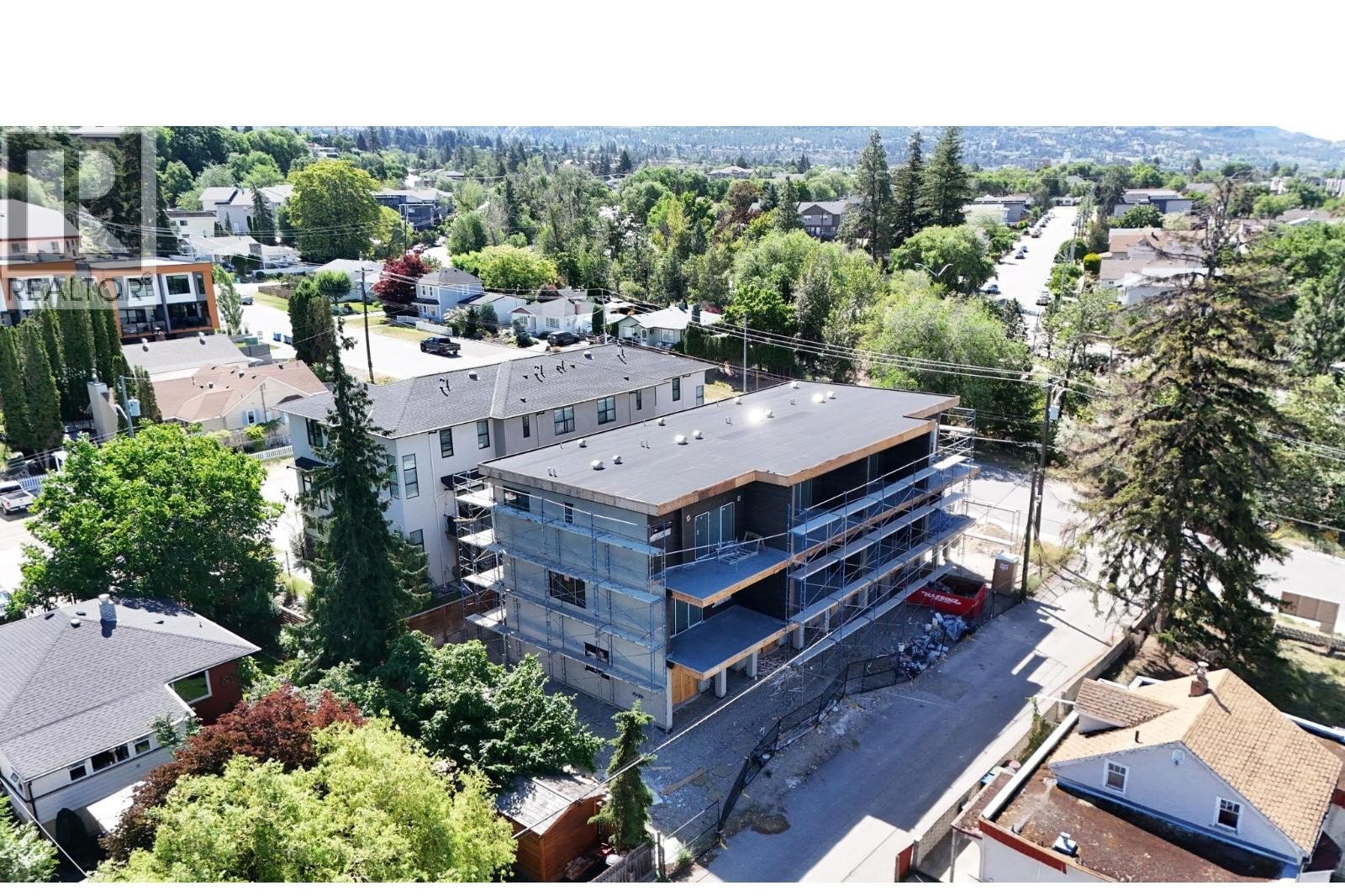 Unit 102 at The Wade Residences, 463 Wade Avenue, Penticton — aerial neighbourhood and construction view