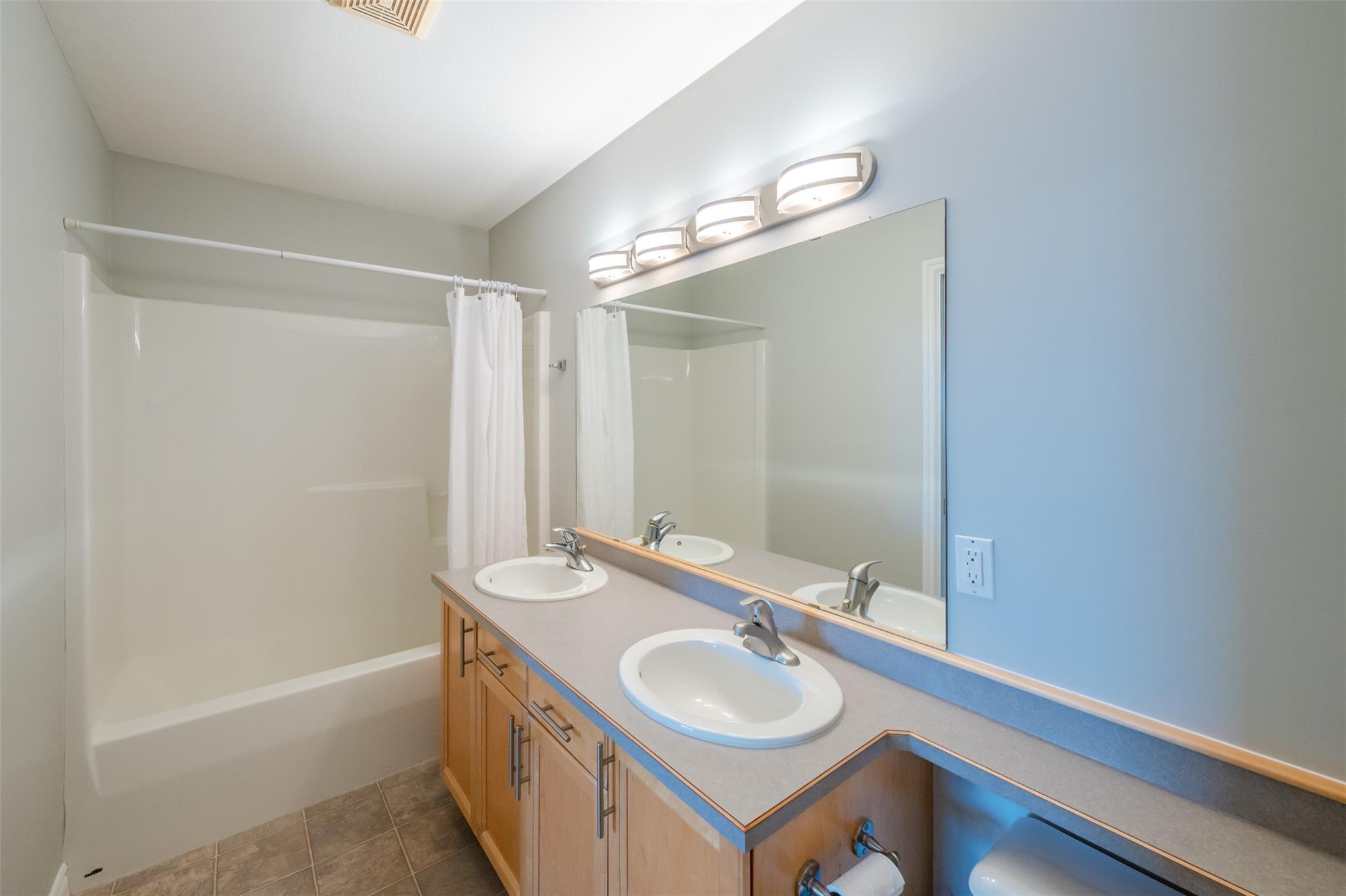 Full bathroom with double vanity in Unit 101.