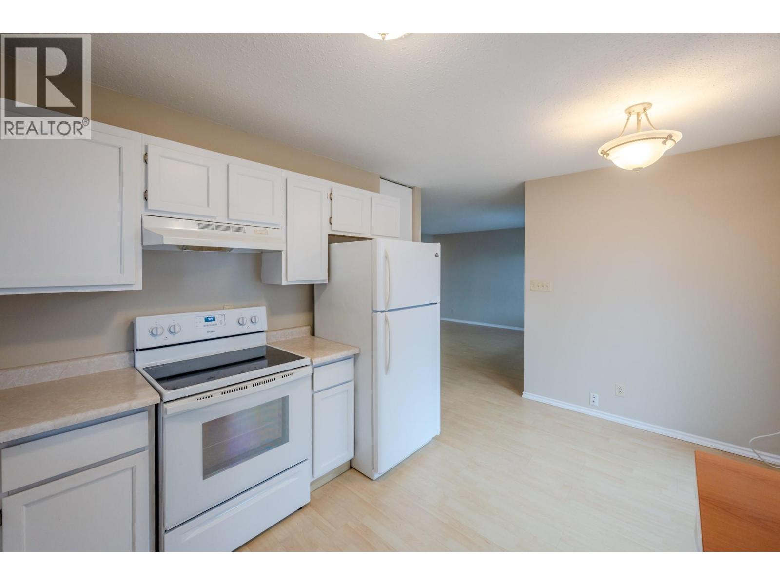 Kitchen and open dining area in Unit 101 at 601 Wade Avenue W, Penticton