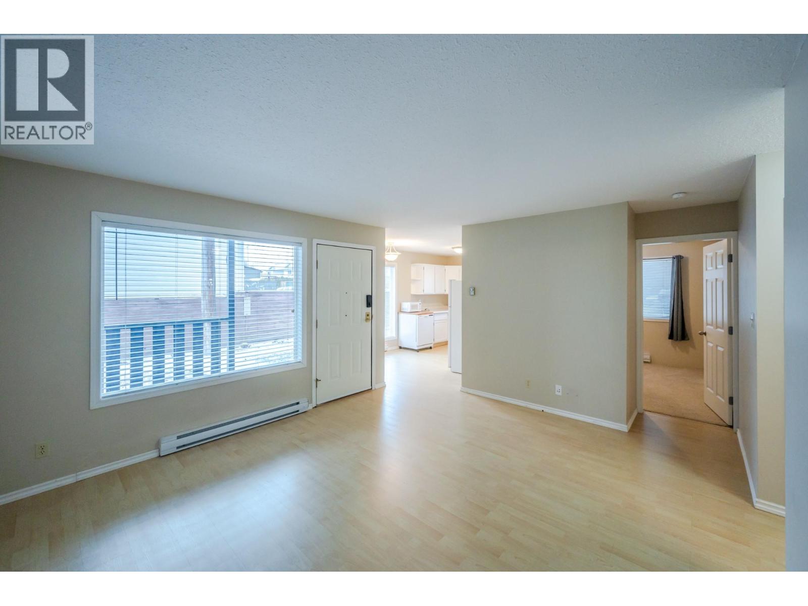 Bright living area with front window in Unit 101 at 601 Wade Avenue W, Penticton