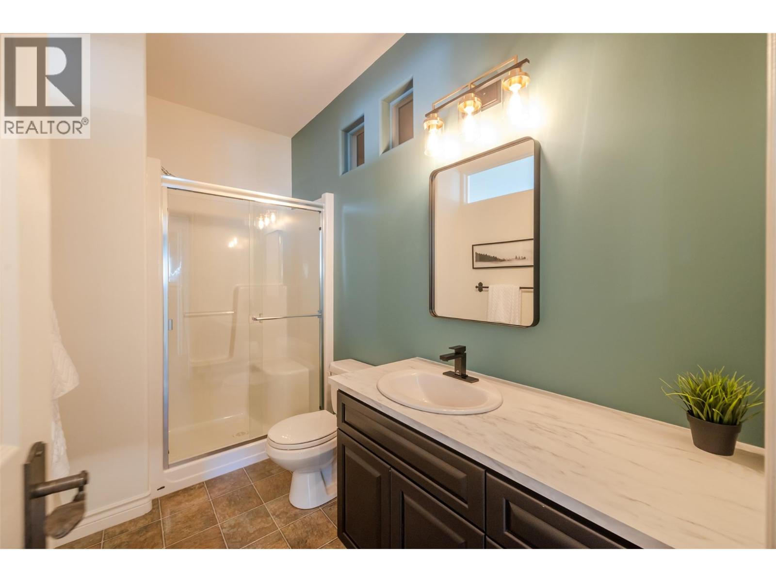 Updated bathroom with glass shower in Unit 102.