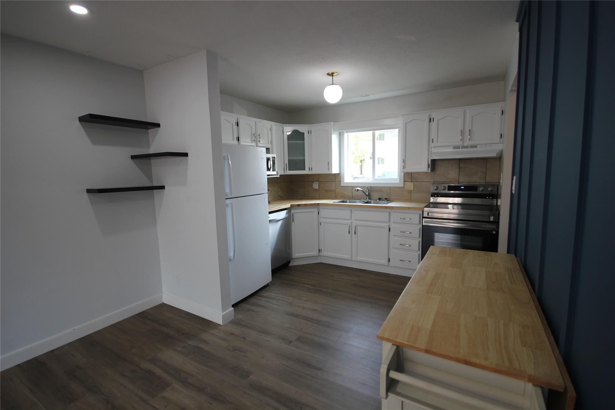 Updated kitchen with white cabinetry in Unit 104.