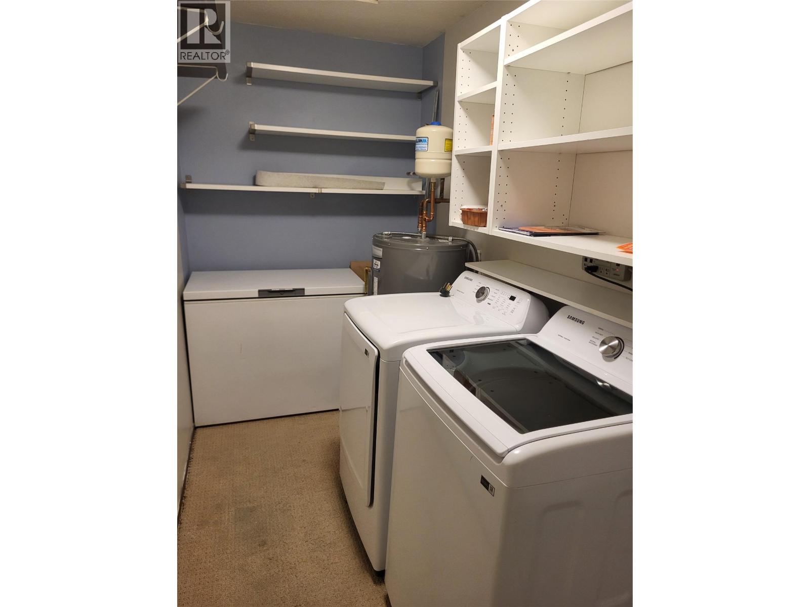 In-suite laundry and shelving in Unit 105 at 601 Wade Avenue W, Penticton