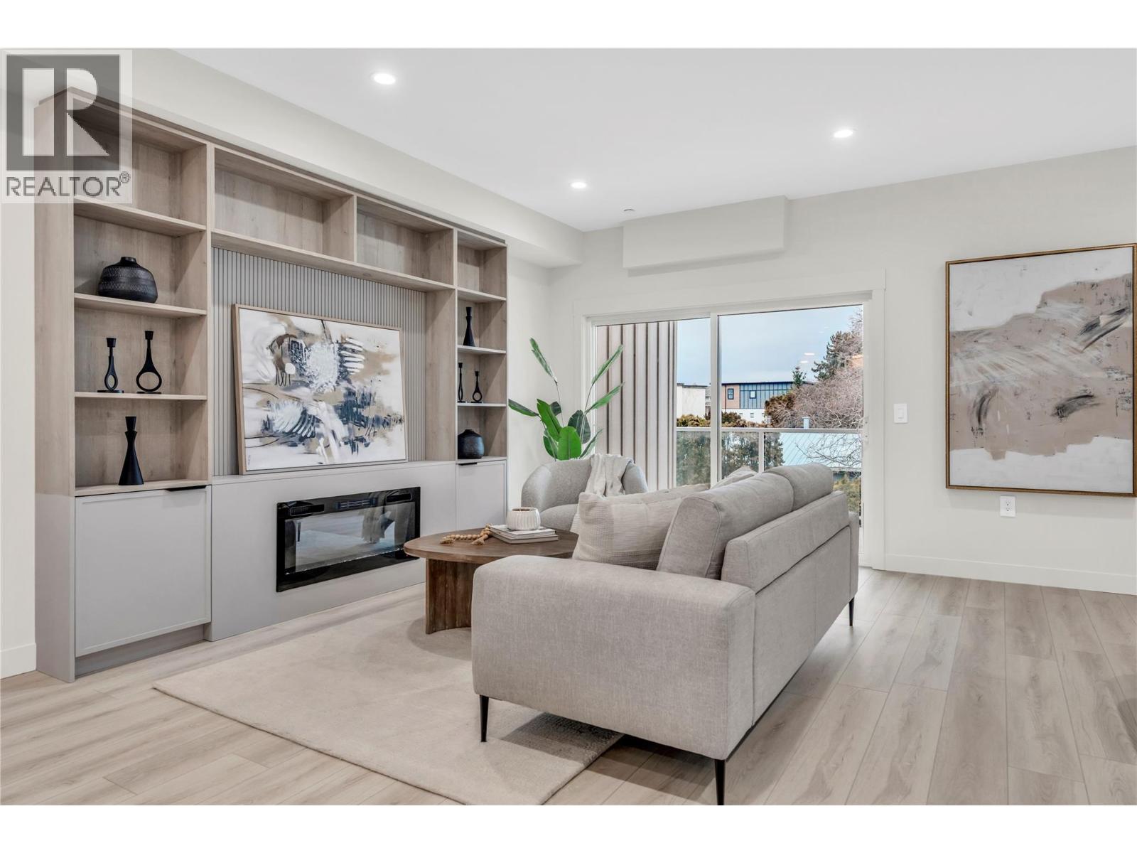 110 784 Argyle Street, Penticton — living room with built-in shelving and fireplace