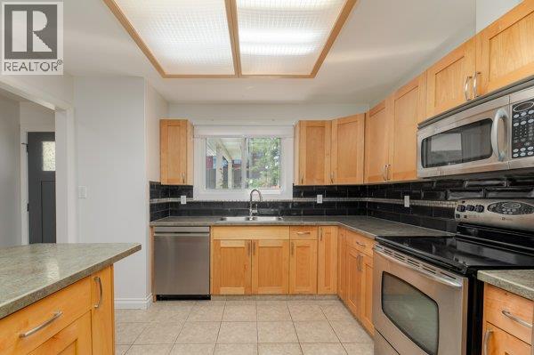 113 3315 Wilson Street, Penticton — wood kitchen with stainless appliances