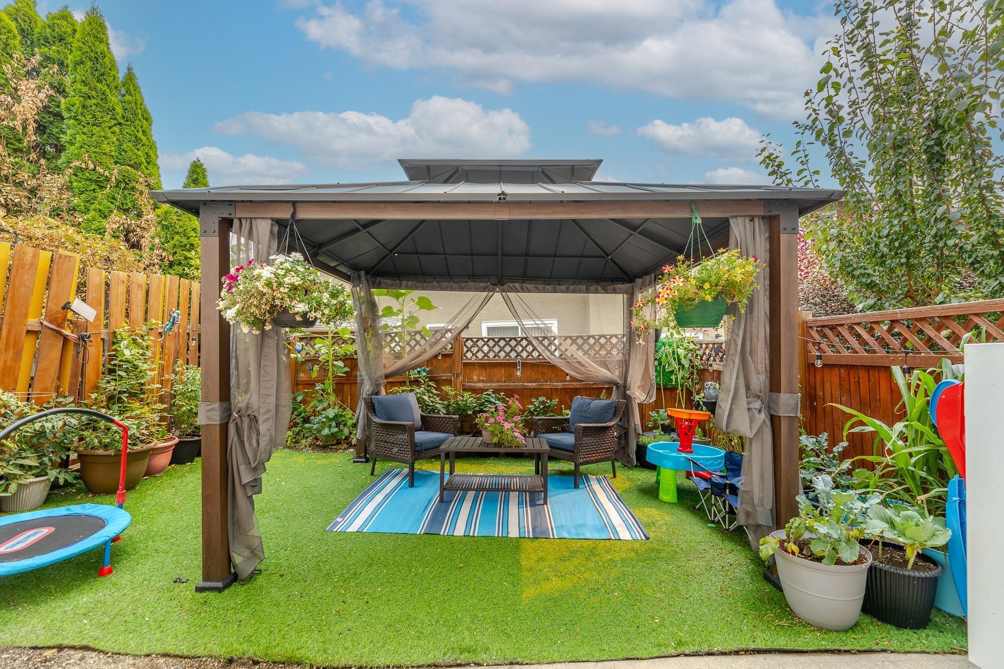 Private fenced backyard retreat with covered gazebo at Unit 124.