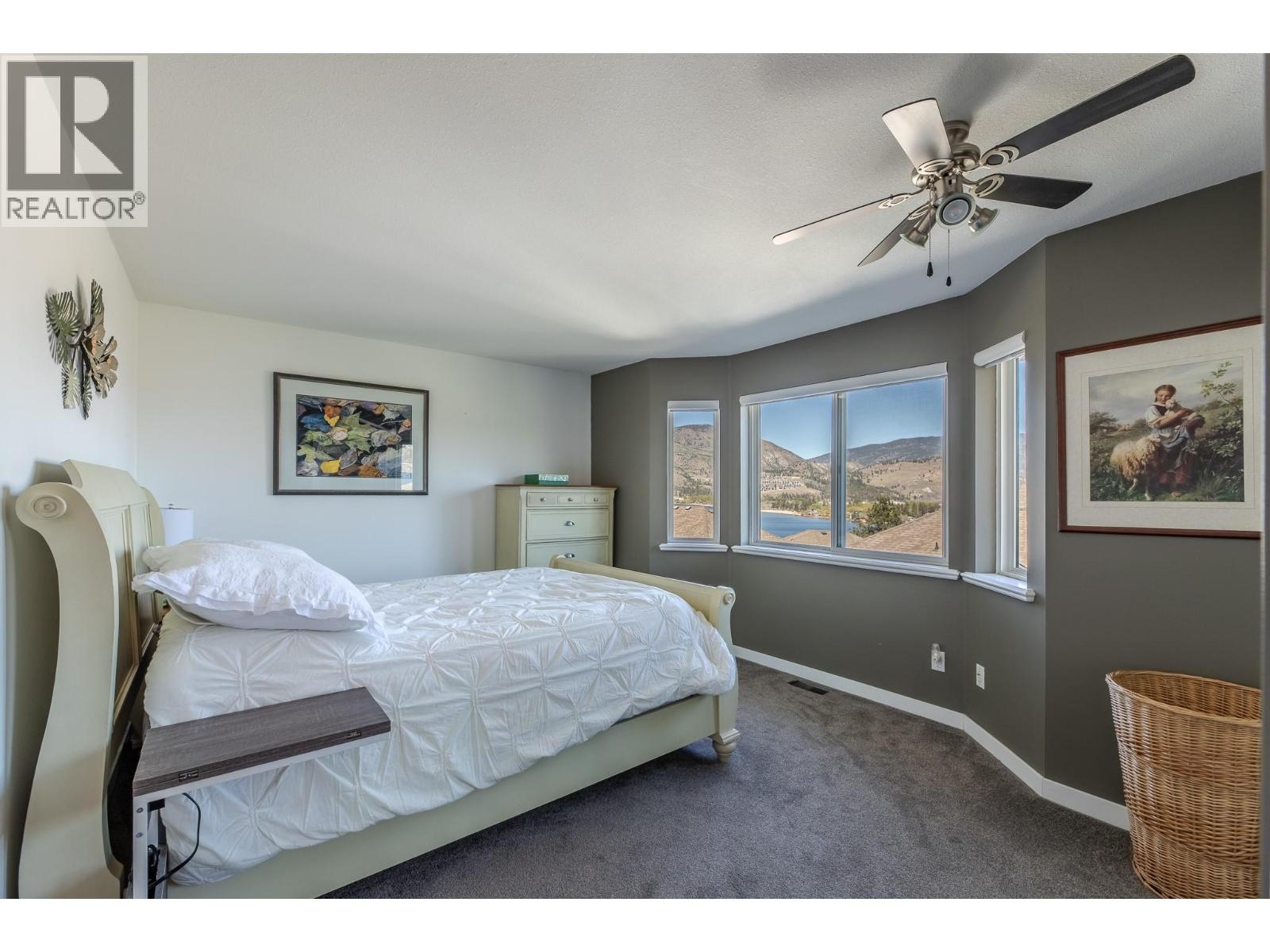 132 3948 Finnerty Road, Penticton — primary bedroom with bay windows