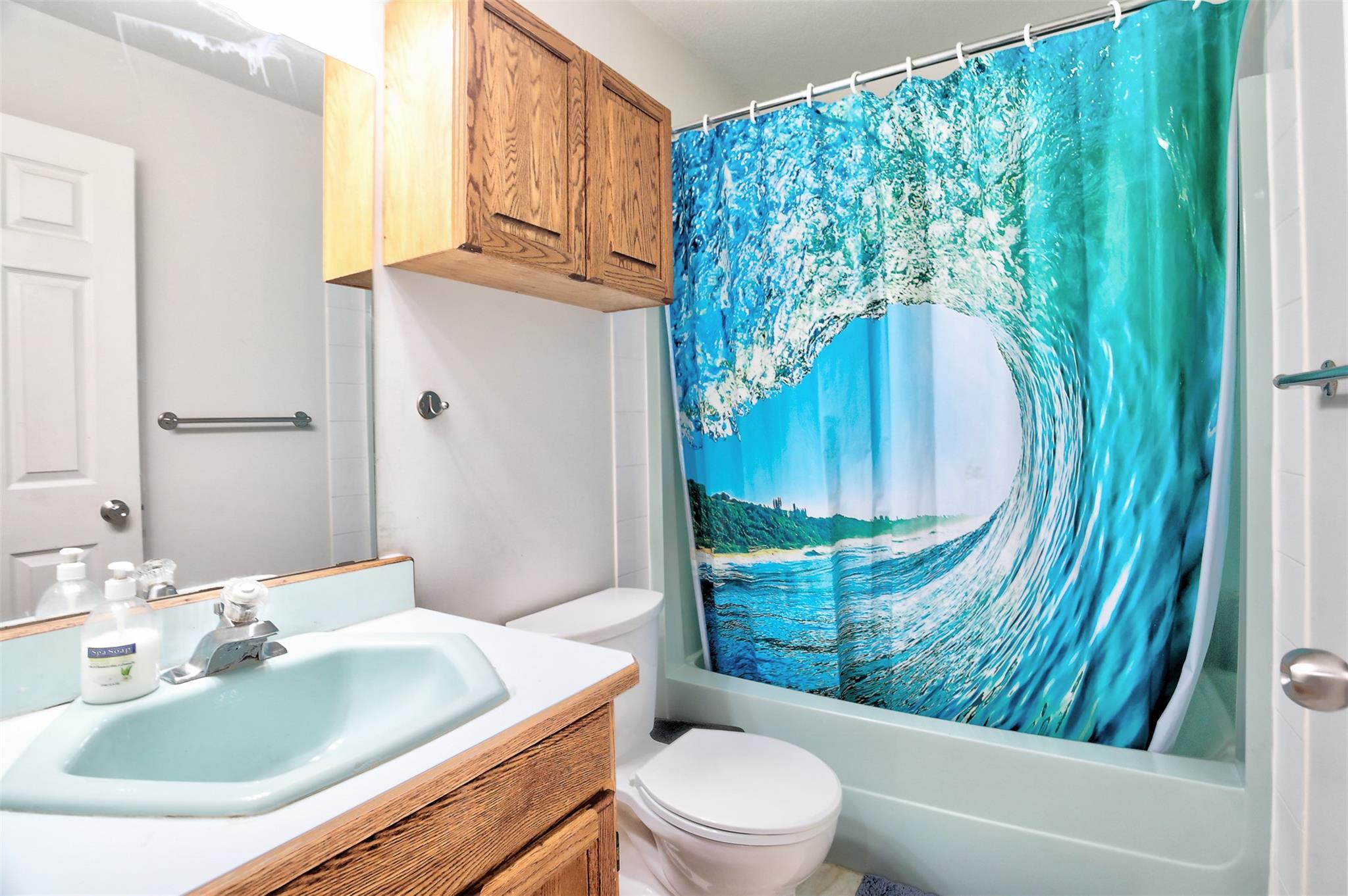 Full bathroom with tub and wood vanity in Unit 203 at 95 Eckhardt Avenue East.
