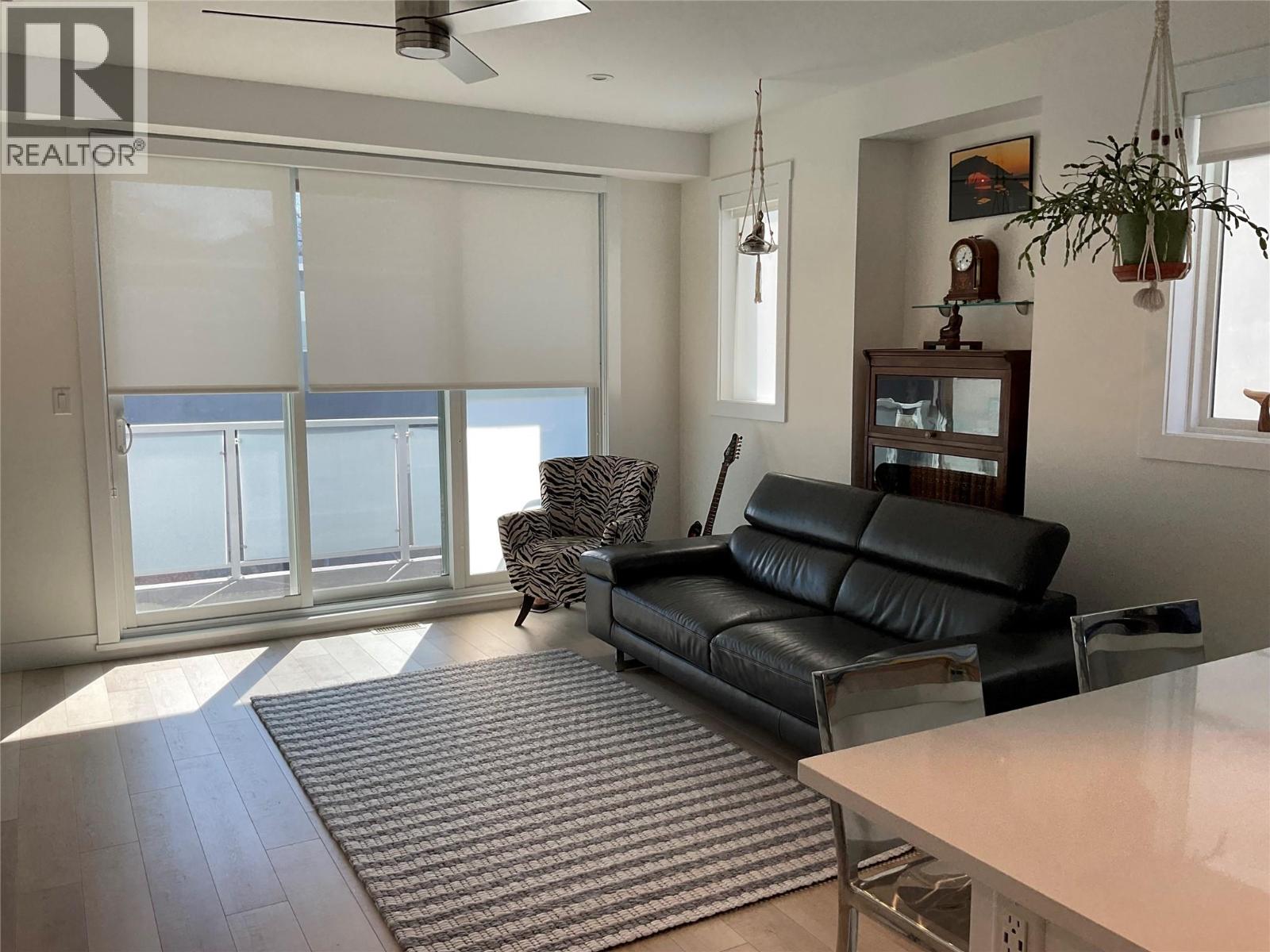 Unit 104 at 210 Scott Avenue, Penticton — living room with deck doors