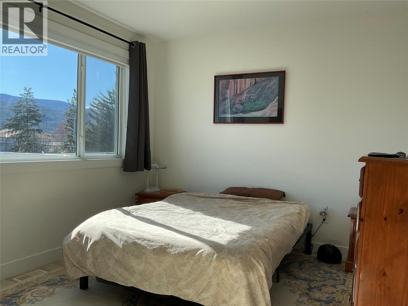 Unit 104 at 210 Scott Avenue, Penticton — primary bedroom with mountain outlook