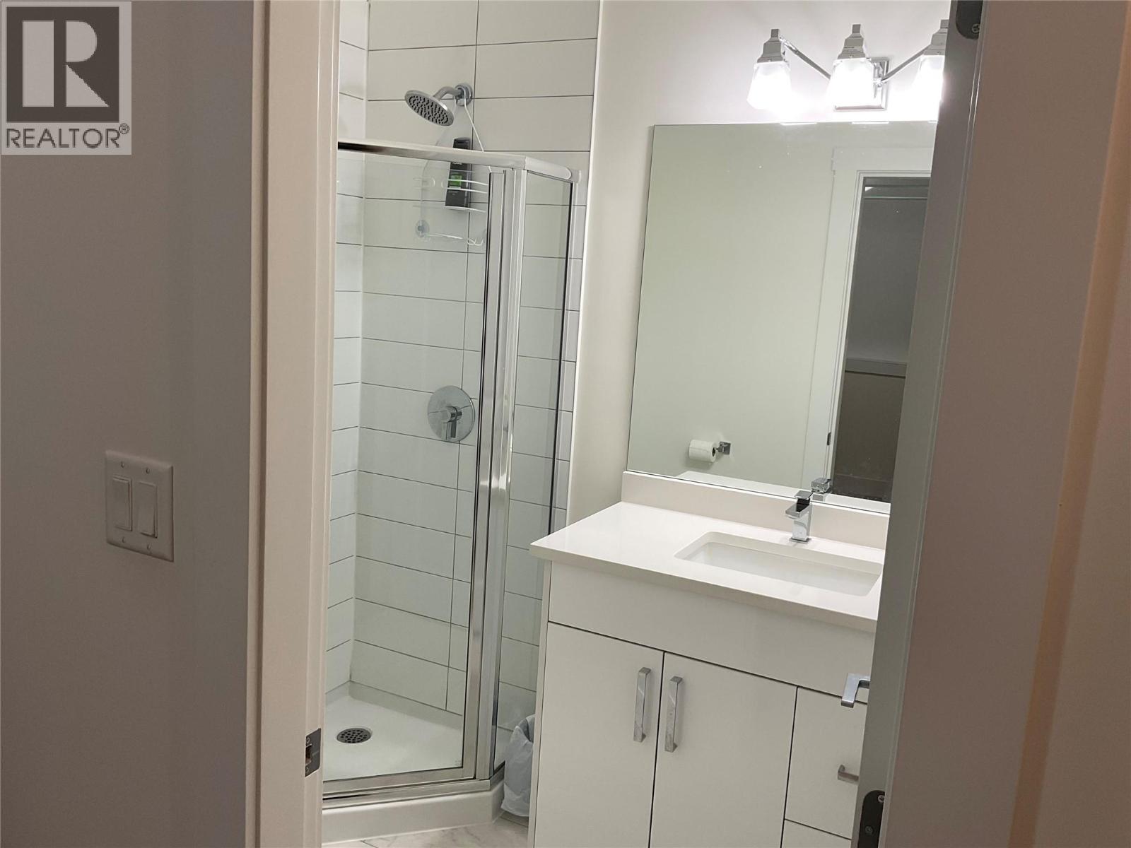 Unit 104 at 210 Scott Avenue, Penticton — full bathroom with glass shower