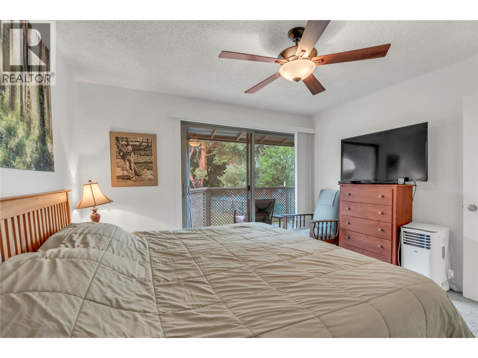 Unit 13 at Skaha Village, 310 Yorkton Avenue, Penticton — primary bedroom with balcony access