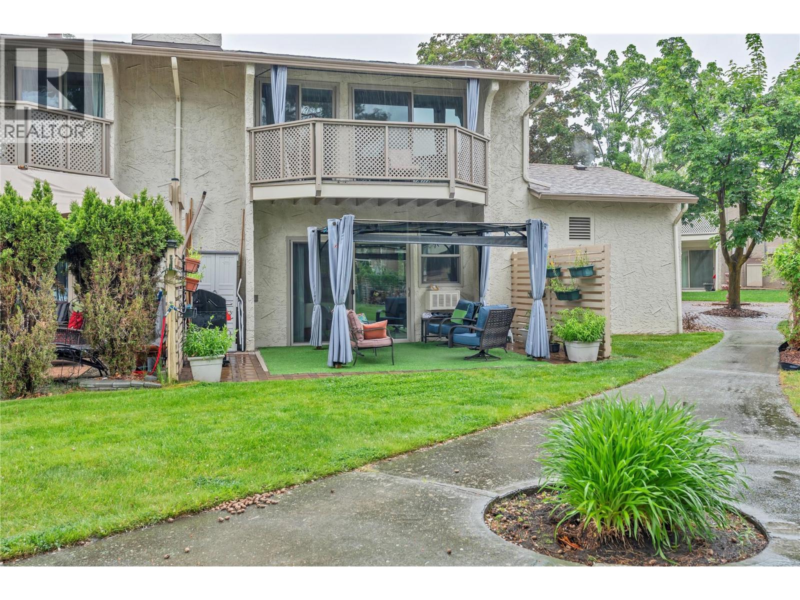 Unit 13 at Skaha Village, 310 Yorkton Avenue, Penticton — rear exterior and landscaped common area