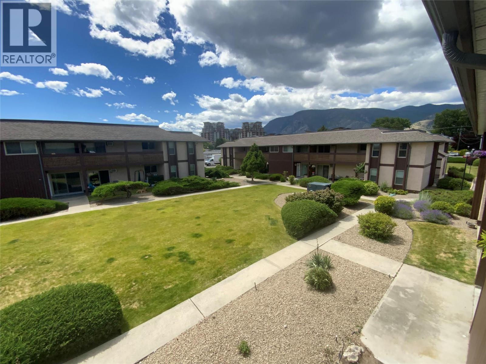 Unit 216 at Tiffany Gardens, 3140 Wilson Street, Penticton — Tiffany Gardens courtyard and mountain outlook