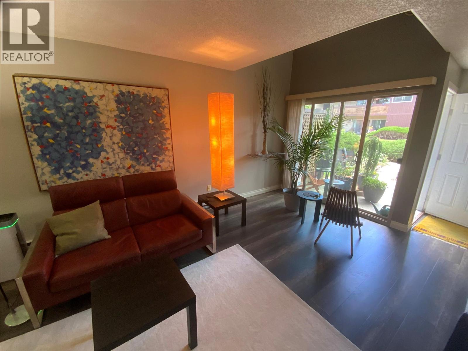 Unit 216 at Tiffany Gardens, 3140 Wilson Street, Penticton — living room with patio doors