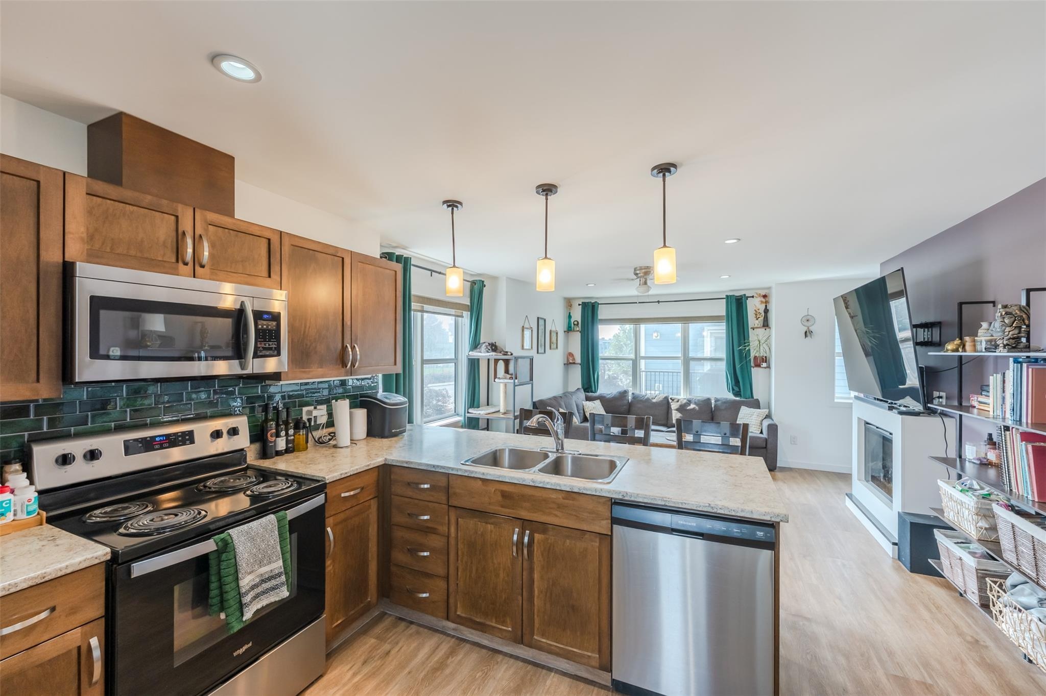 Open kitchen with island and stainless appliances in Unit 102.