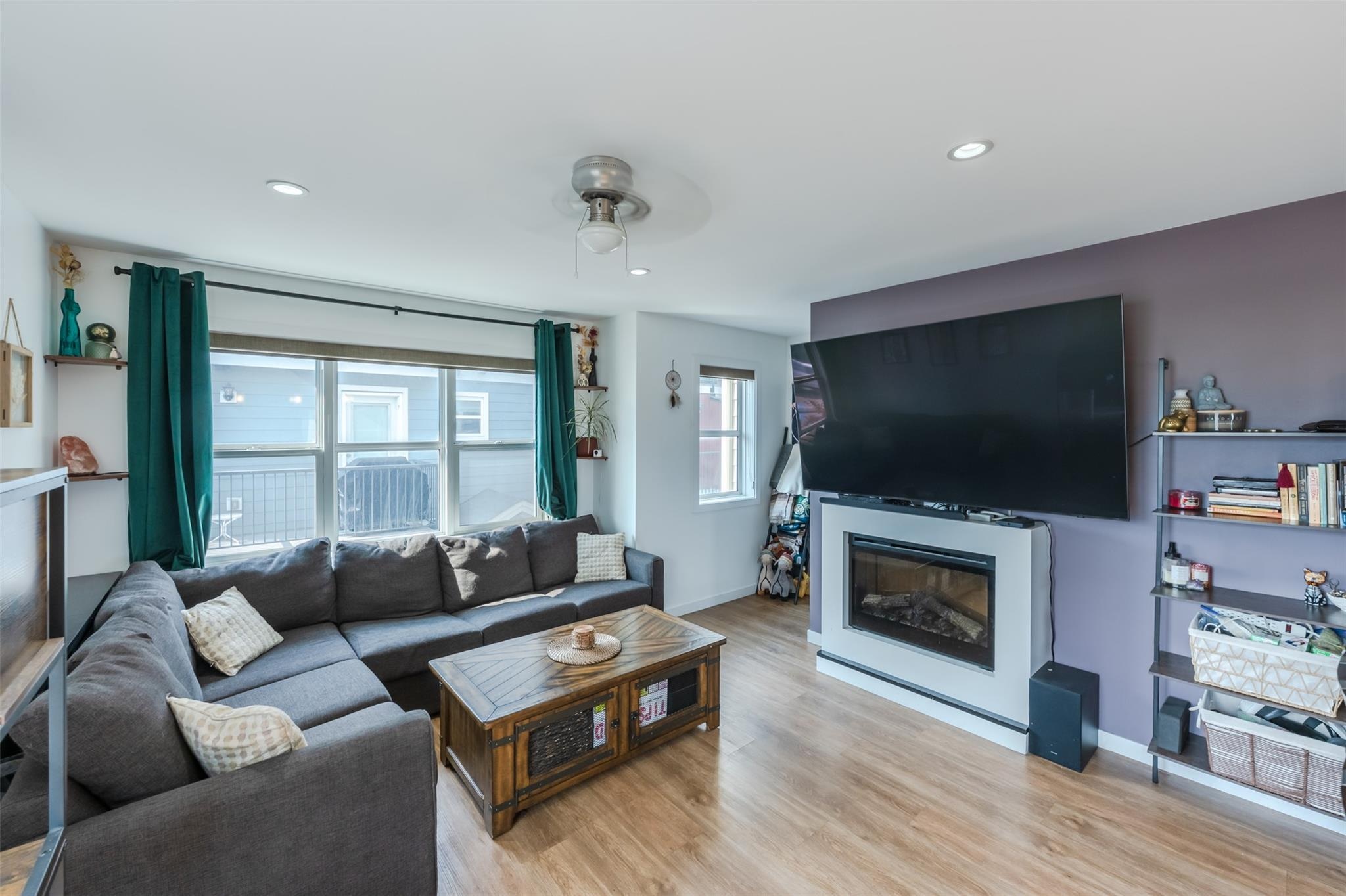 Living room with large windows and fireplace in Unit 102.