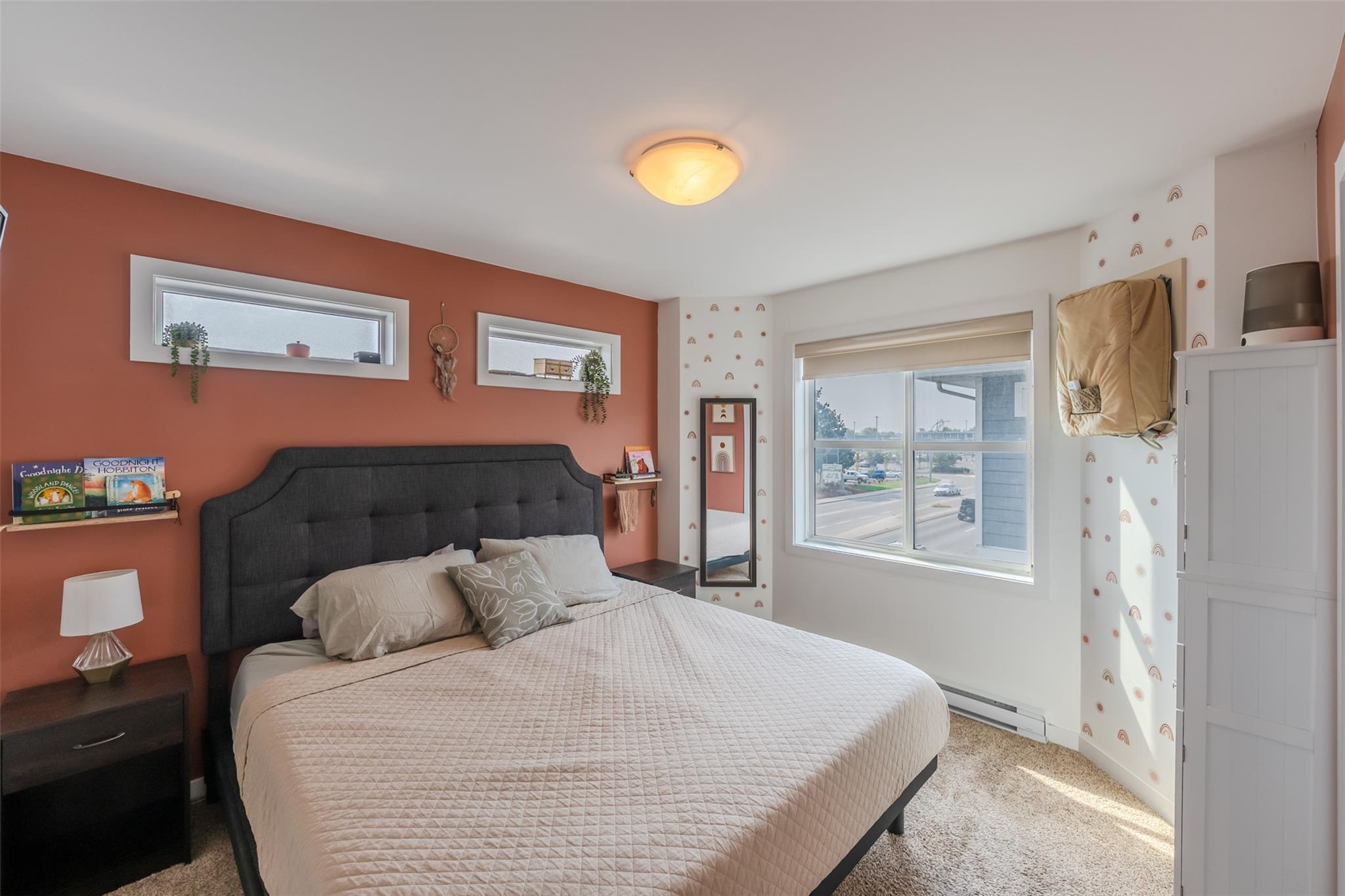 Primary bedroom with large windows in Unit 102.