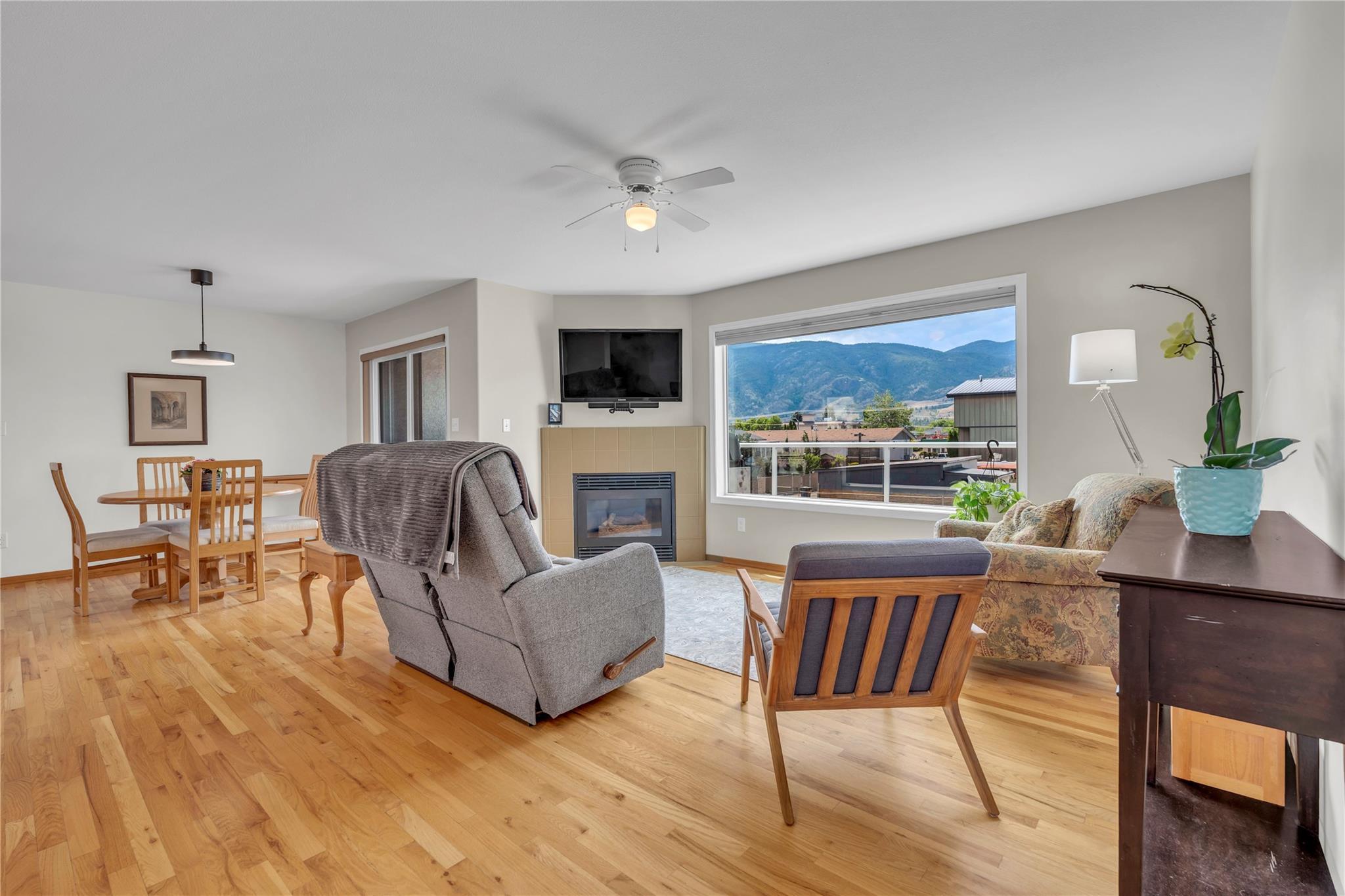 103 166 Green Avenue W, Penticton — open living area with gas fireplace and mountain outlook