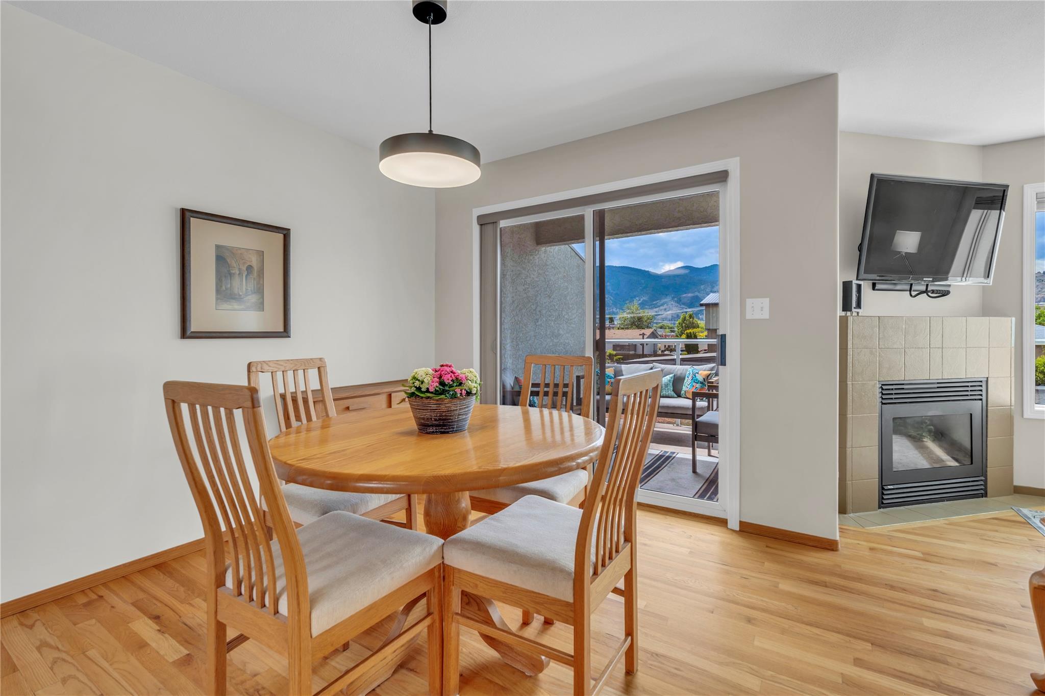 103 166 Green Avenue W, Penticton — dining area with fireplace and covered balcony access