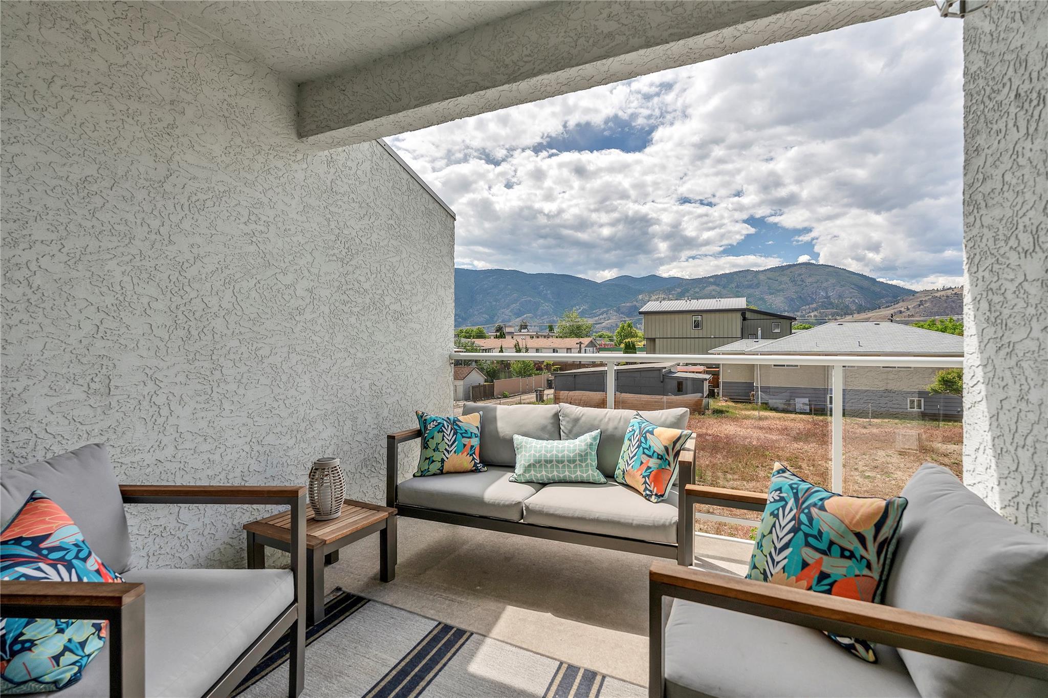 103 166 Green Avenue W, Penticton — covered balcony seating area with mountain view