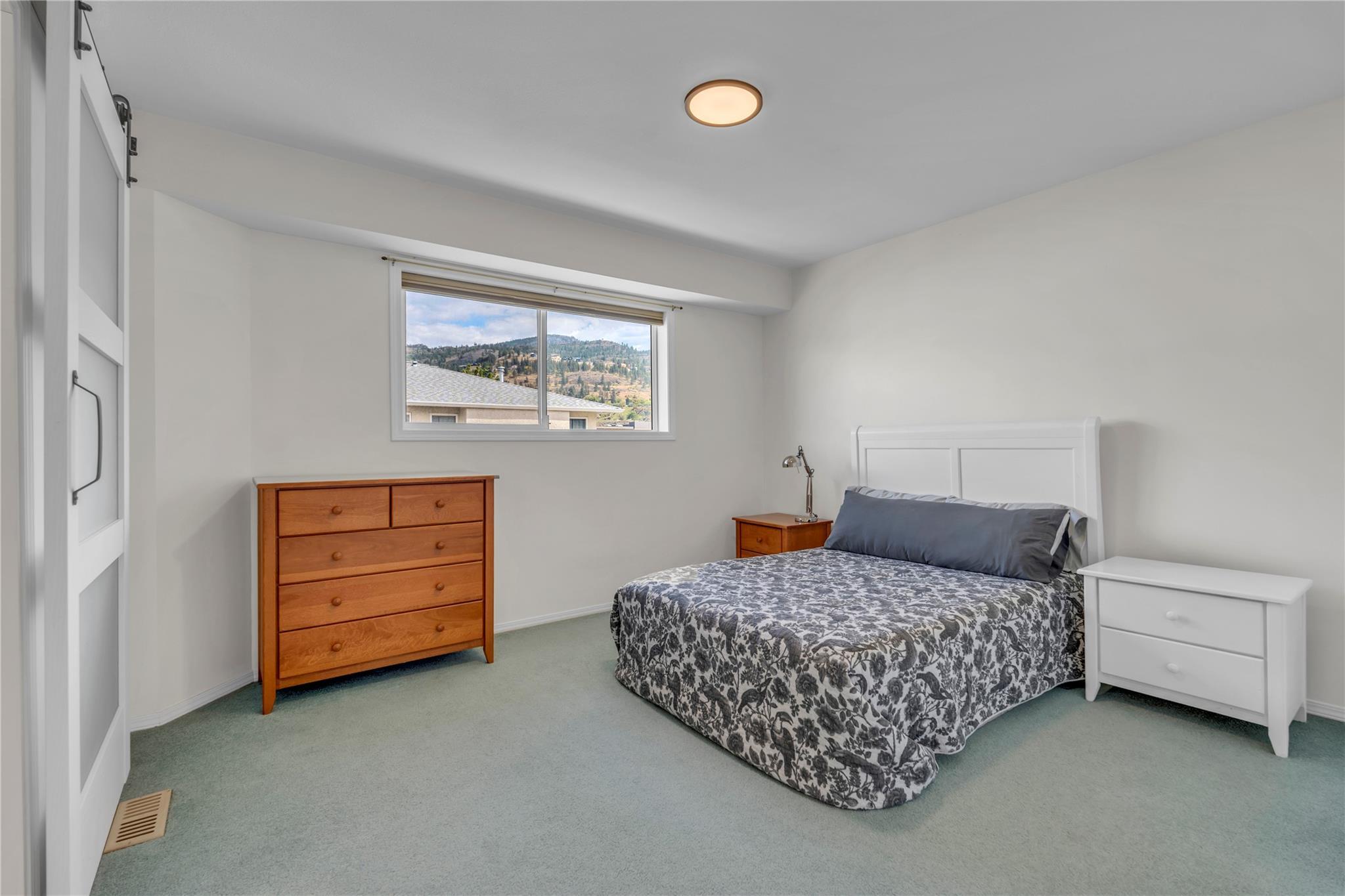 103 166 Green Avenue W, Penticton — primary bedroom with built-in closets and mountain view