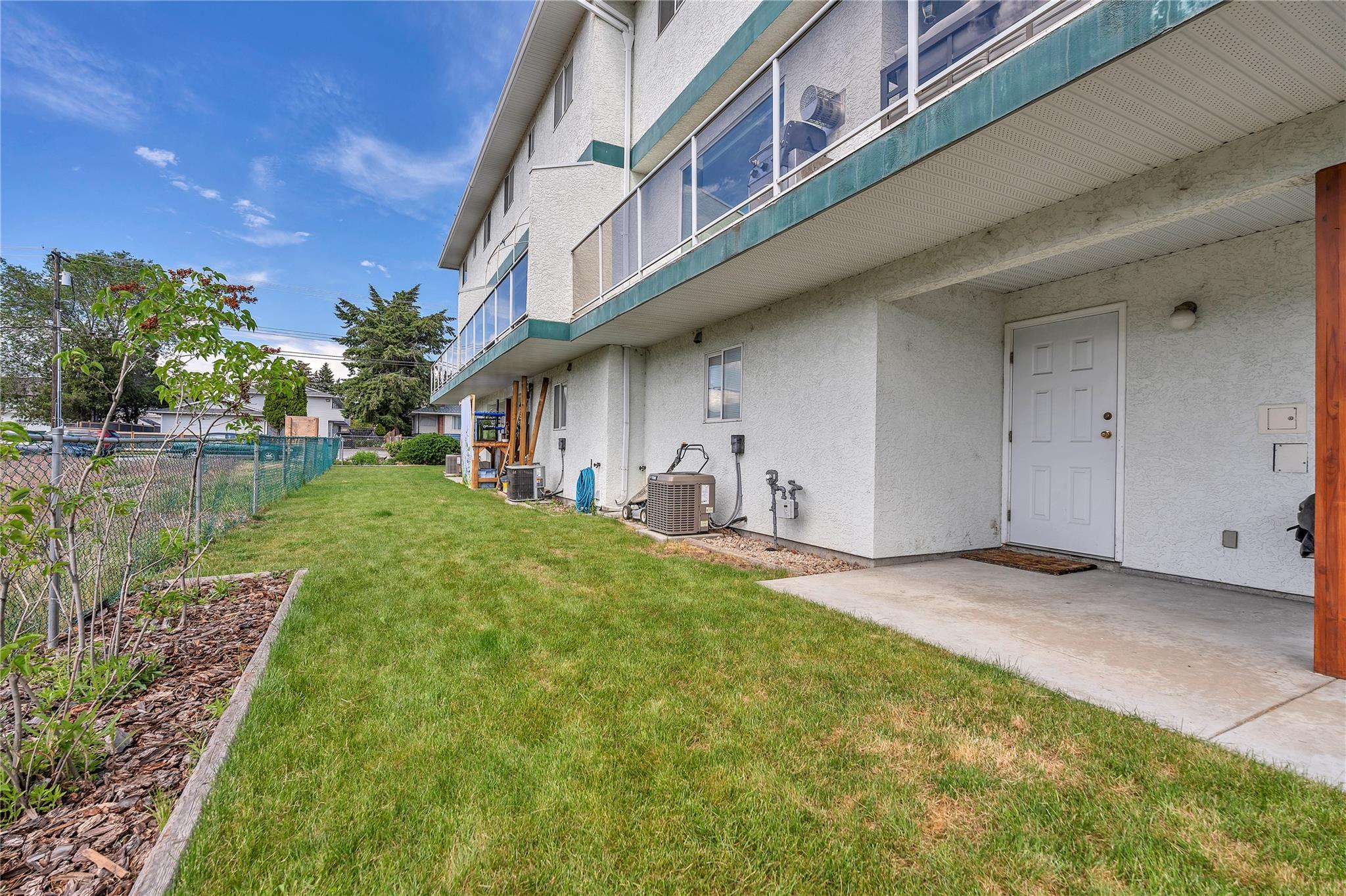 103 166 Green Avenue W, Penticton — shared landscaped side yard and lower patio area