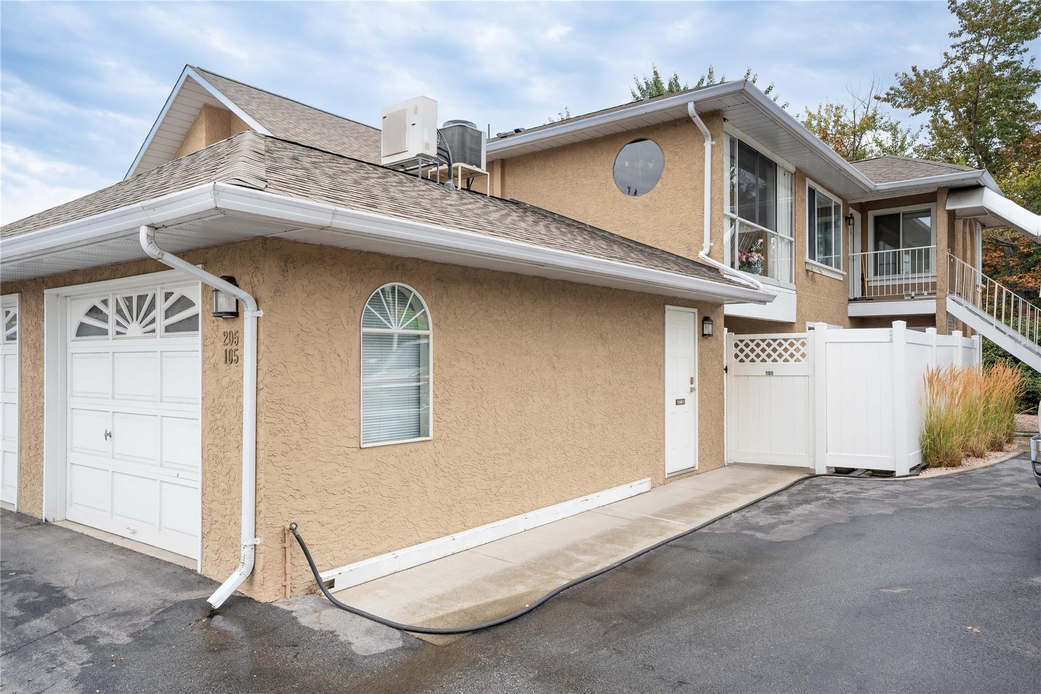 Front exterior and attached garage of Unit 105 at Brandon Park in Penticton.