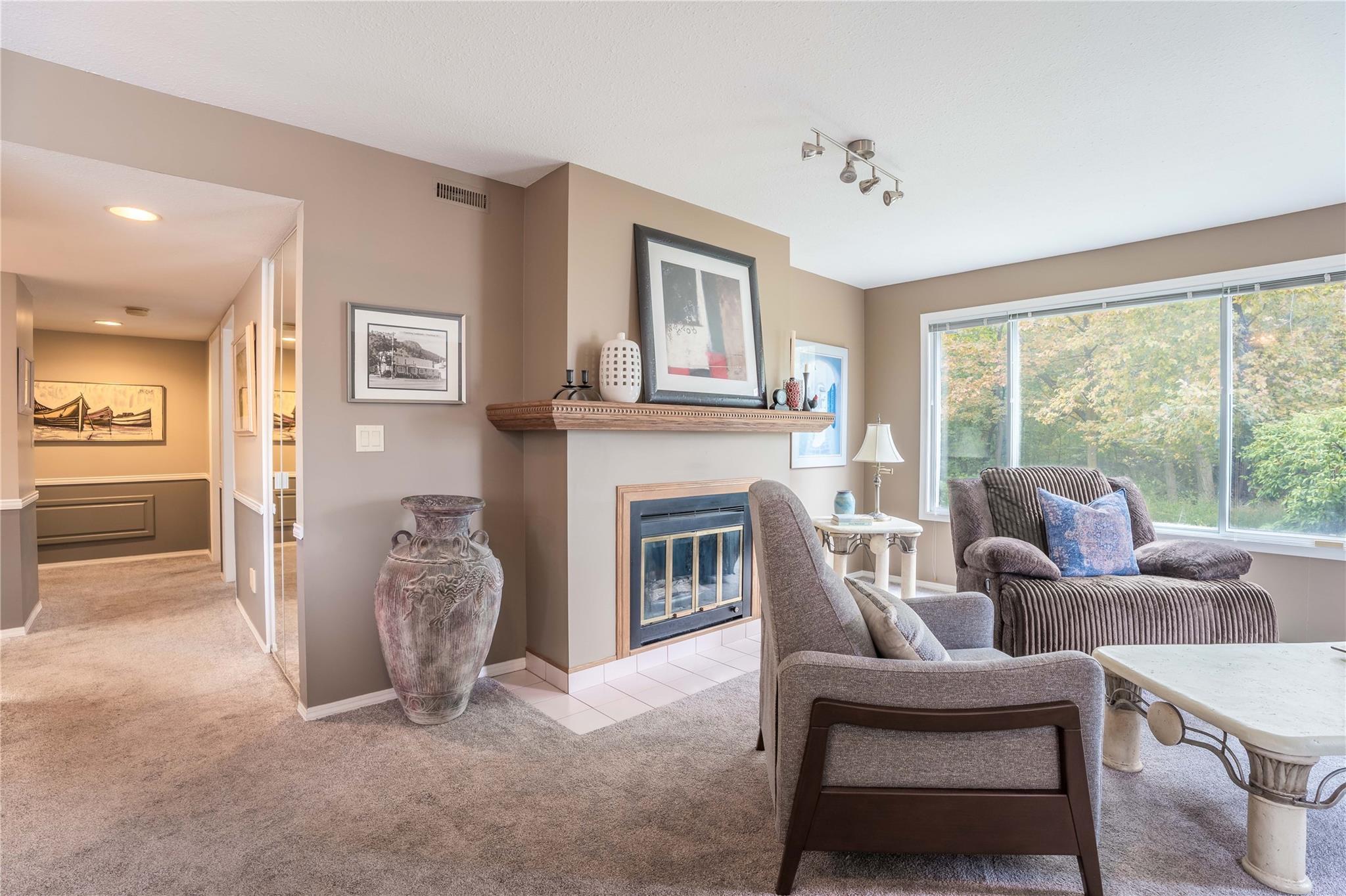 Living room with gas fireplace and large window in Unit 105.