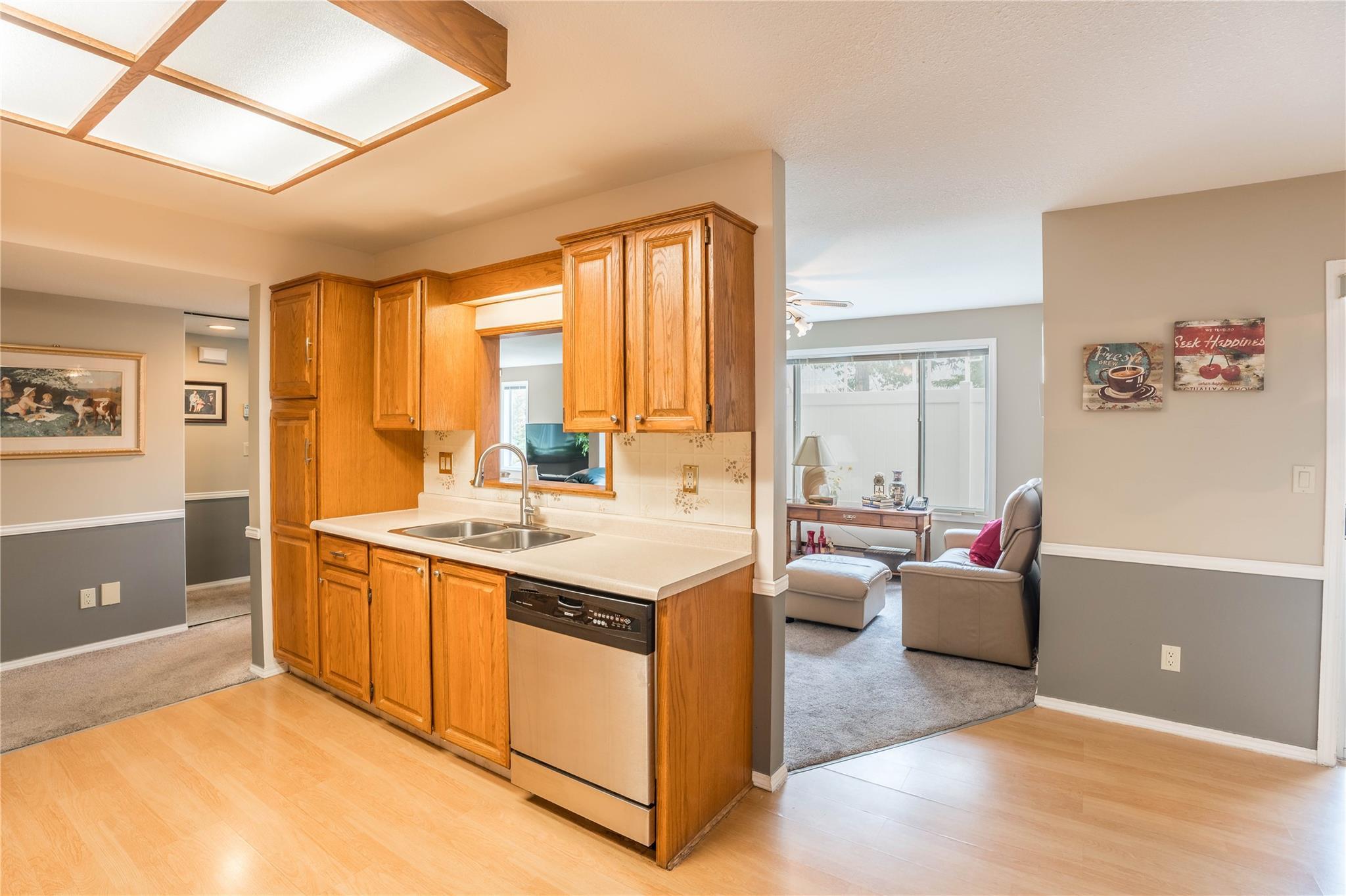 Kitchen with wood cabinetry and stainless appliances in Unit 105.
