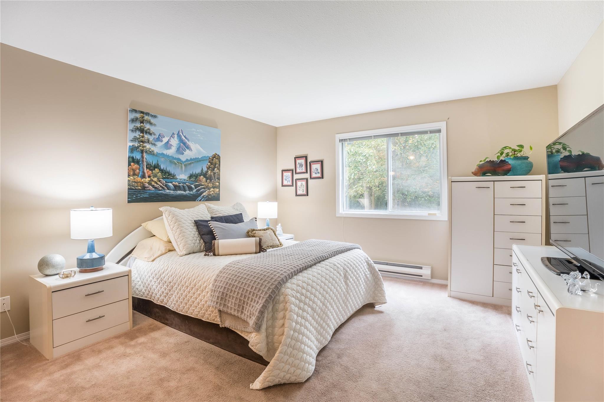 Primary bedroom with generous windows and storage in Unit 105.