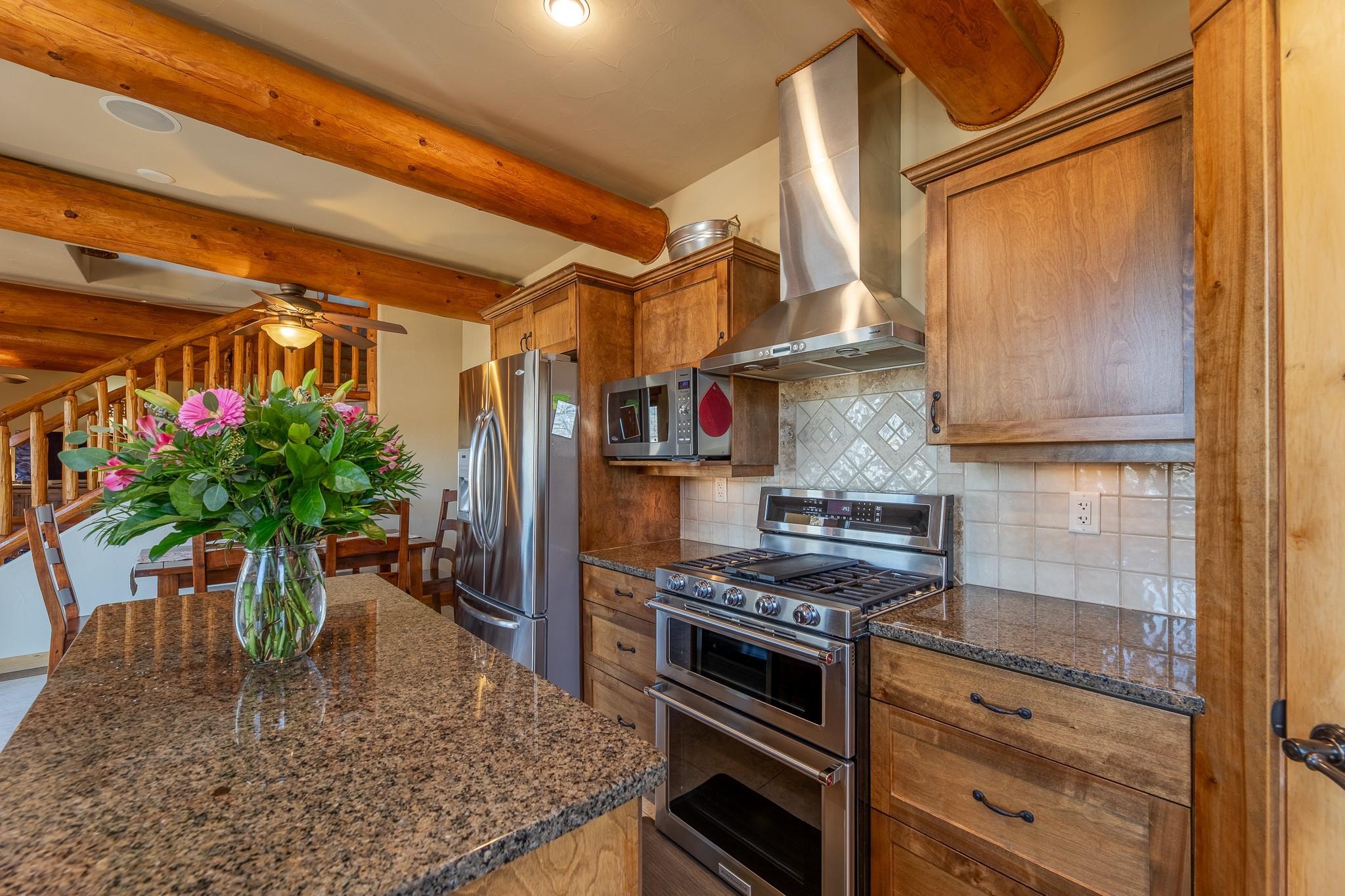 Kitchen with granite counters, wood cabinetry and stainless appliances at Unit 105.