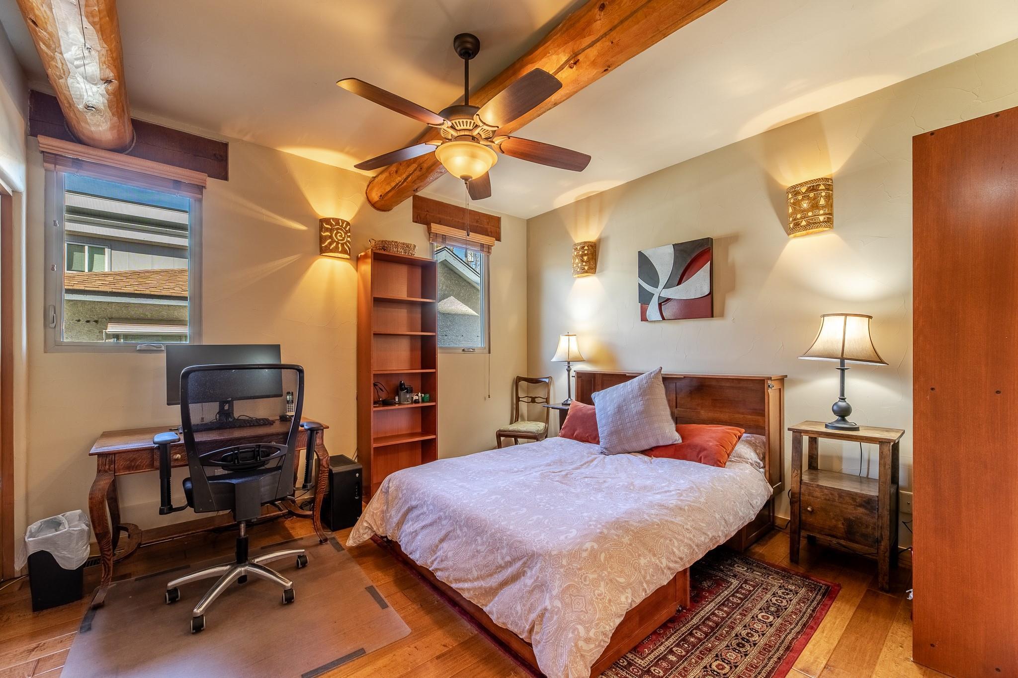 Flexible bedroom or office with exposed beams at Unit 105.