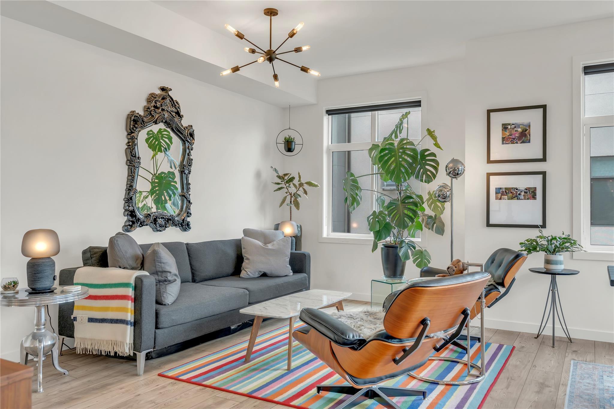 Living room with large windows and modern fixtures in Unit 115.