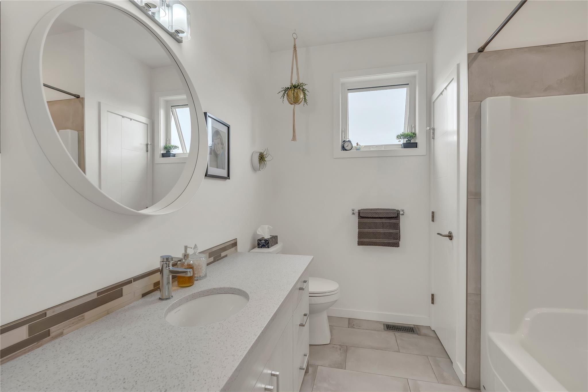 Bathroom with long vanity and tub-shower in Unit 115.
