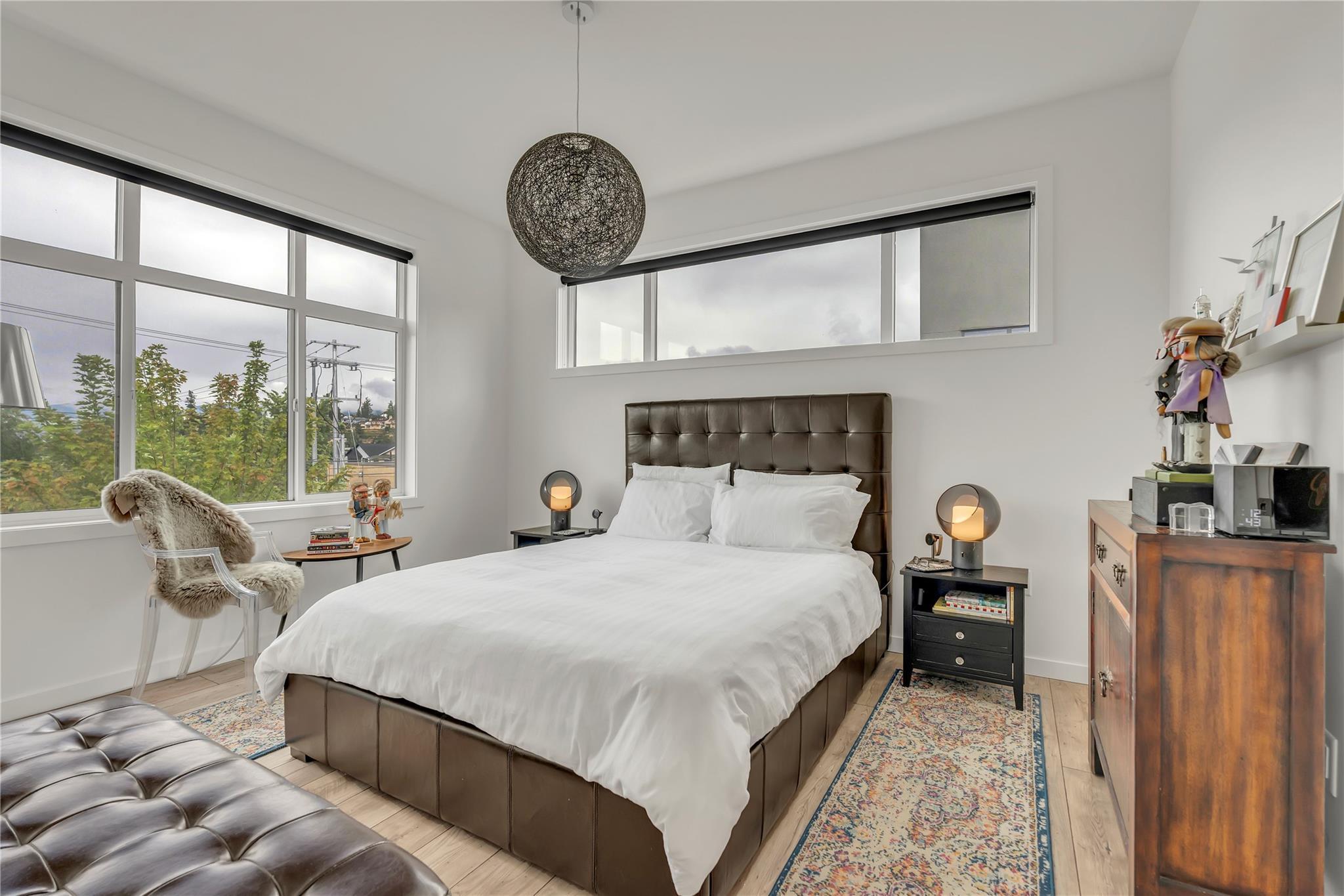 Primary bedroom with large corner windows in Unit 115.