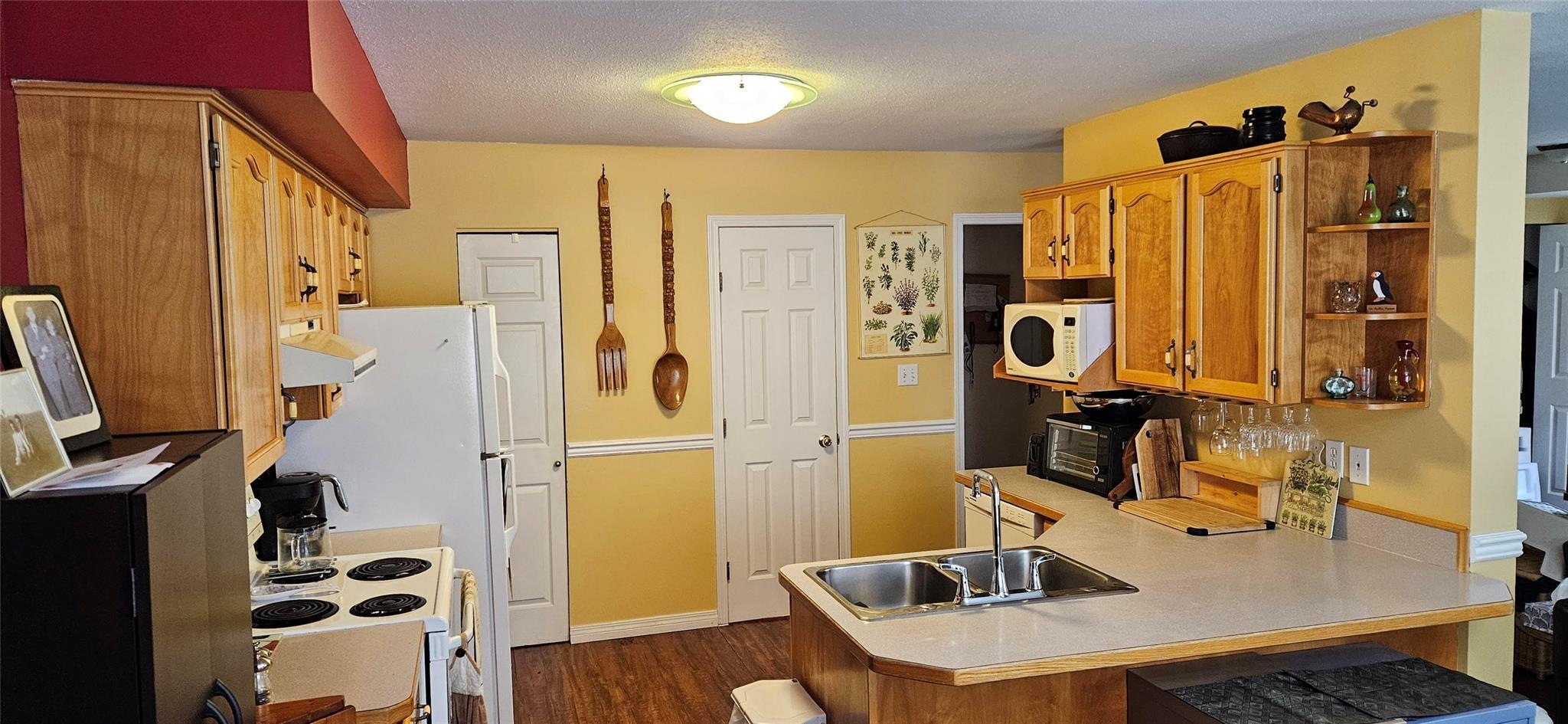Kitchen with wood cabinetry and peninsula sink at Unit 119.