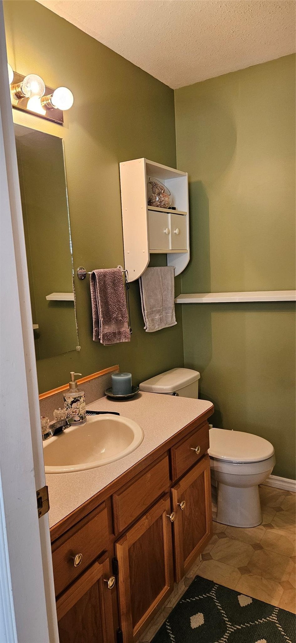 Full bathroom with wood vanity at Unit 119.