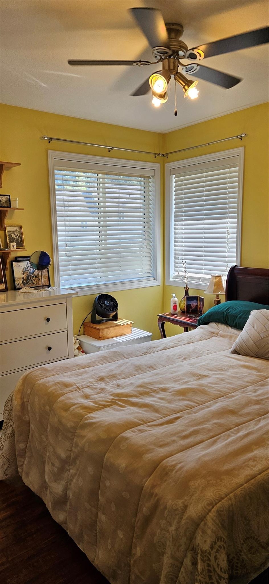 Bedroom with two windows and ceiling fan at Unit 119.