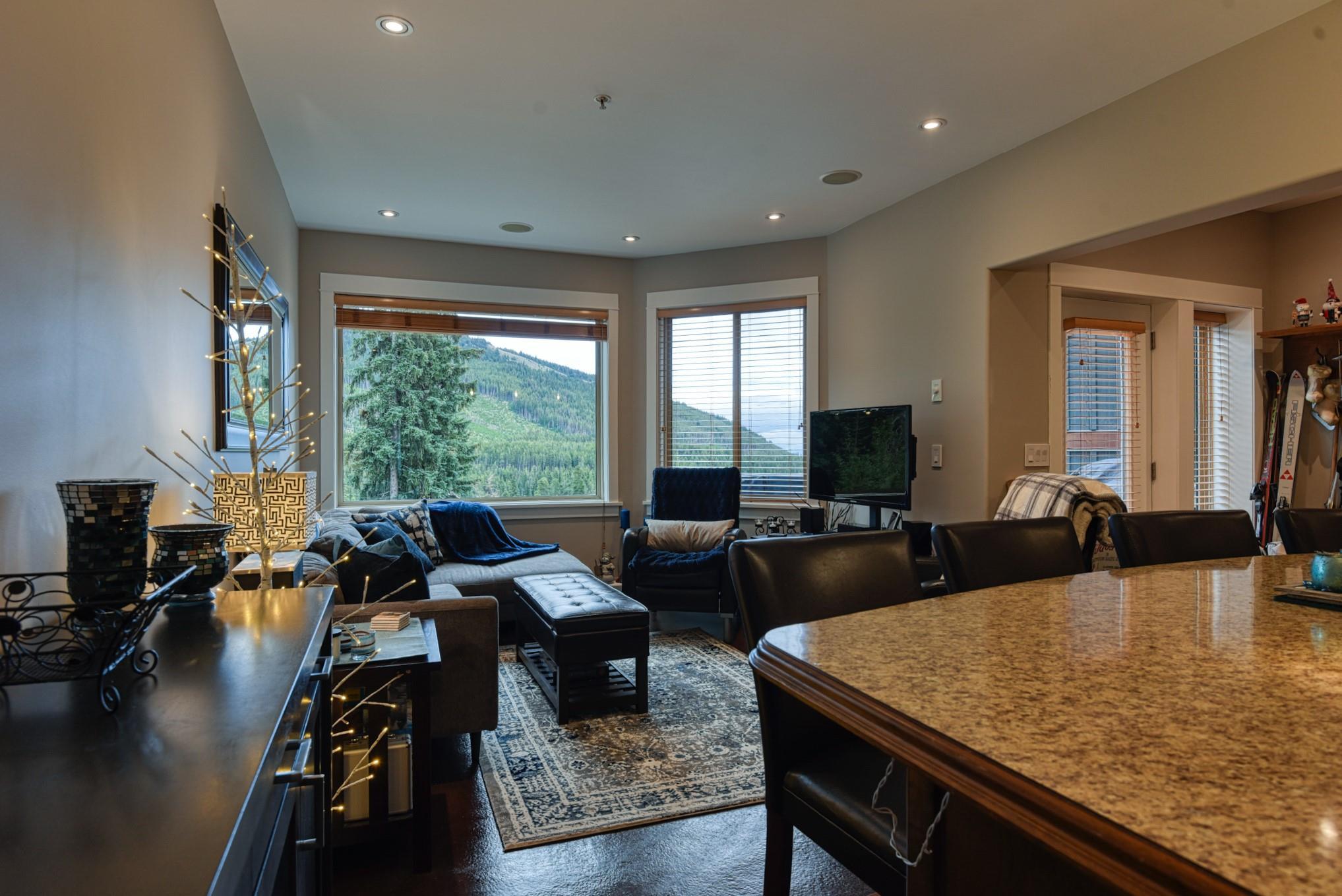 Open-plan living, dining and kitchen area with mountain views at Unit 12 in Snowridge.