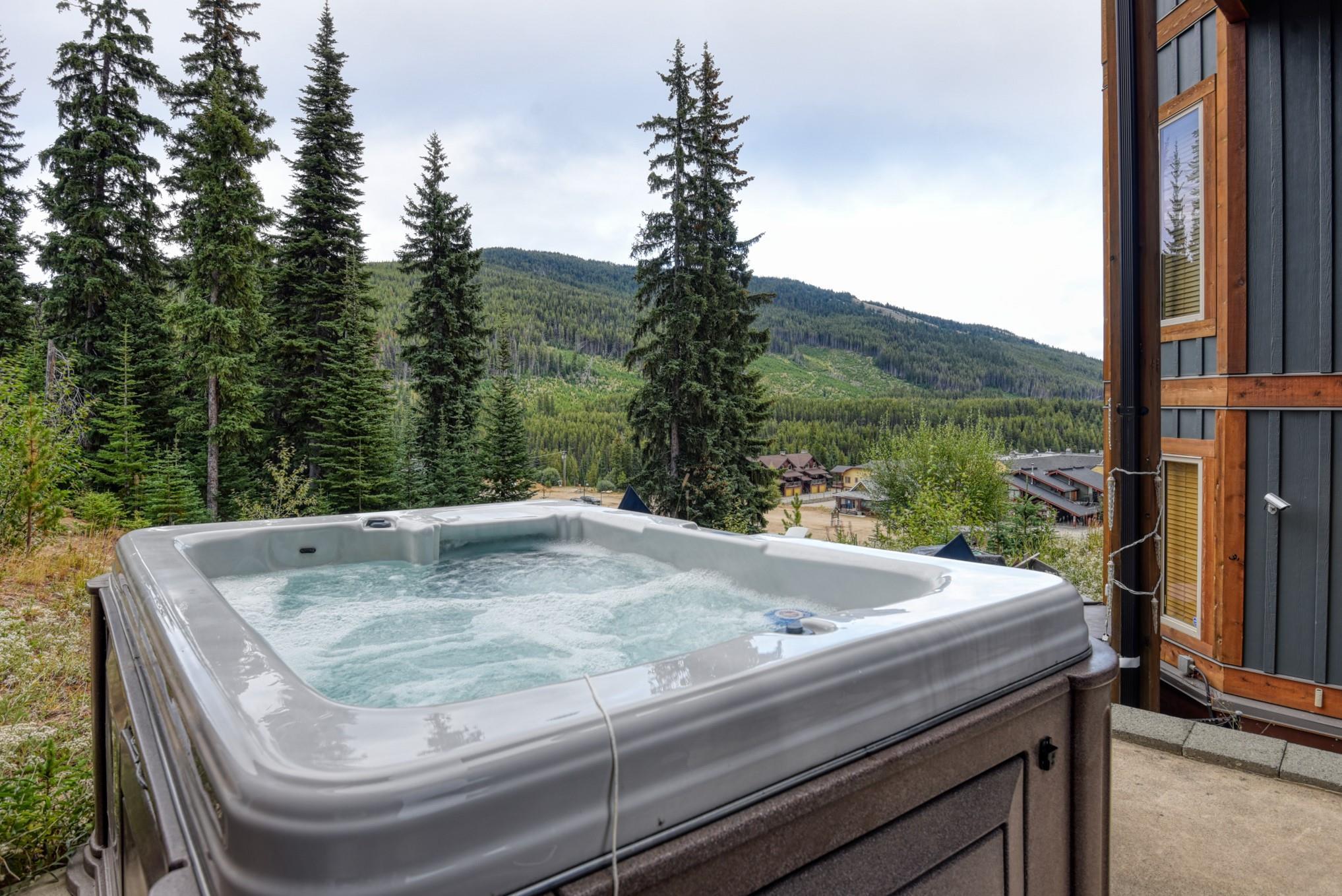 Private hot tub overlooking the forest and mountain setting at Unit 12 in Snowridge.