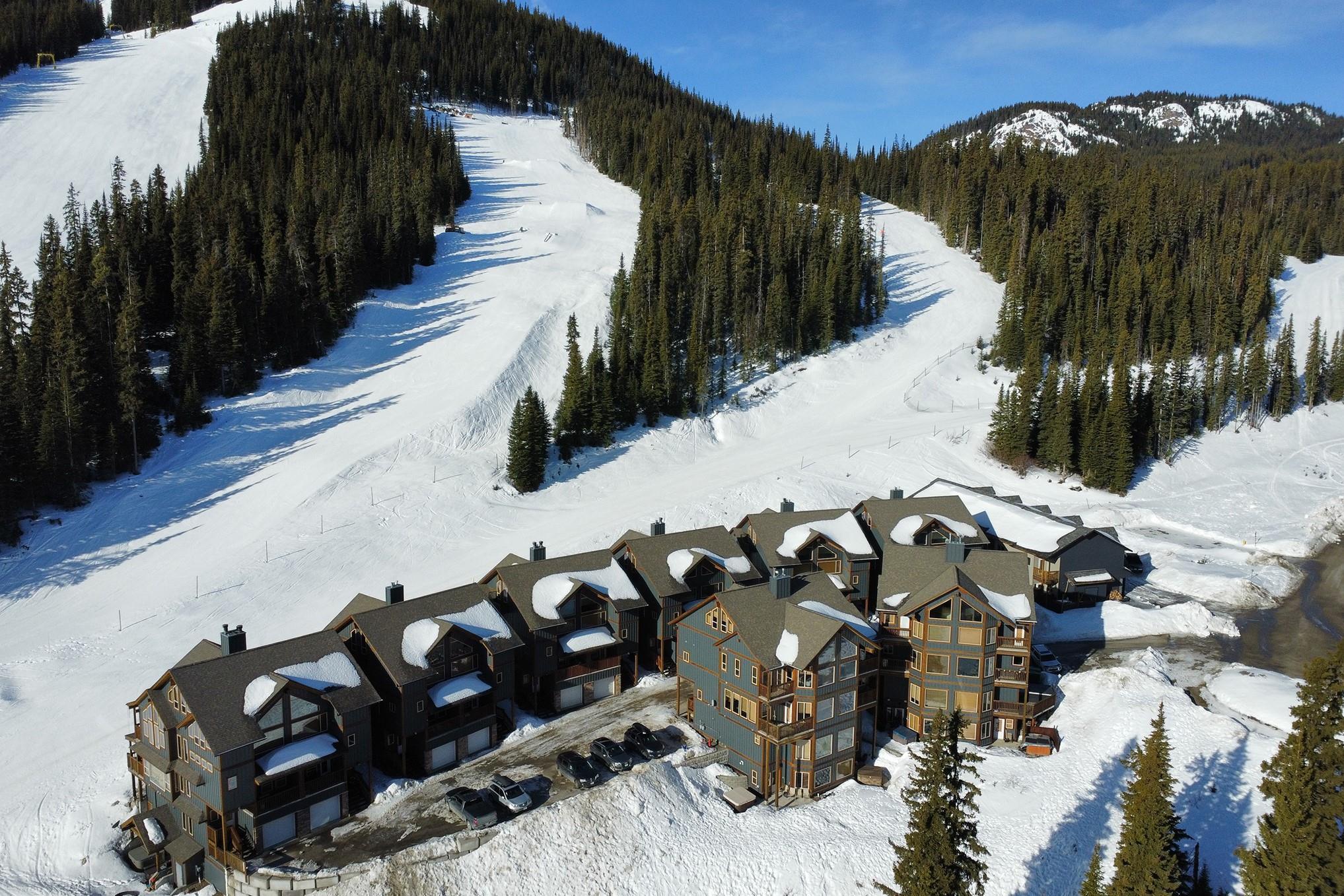 Aerial winter view of Snowridge beside an Apex Mountain ski run.
