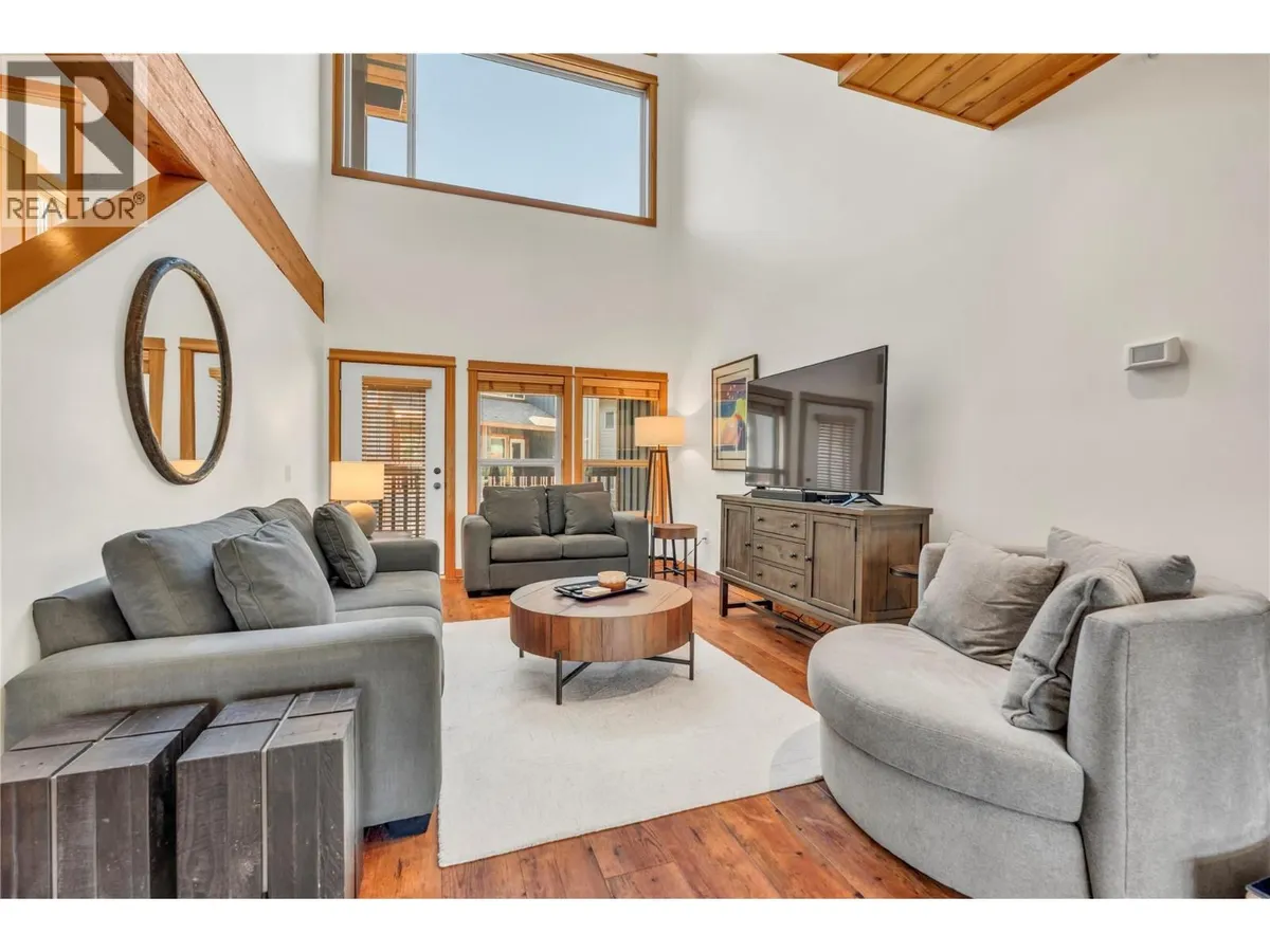 Living room with vaulted wood-beam ceiling and stone-faced fireplace at 14-306 Creekview Road.