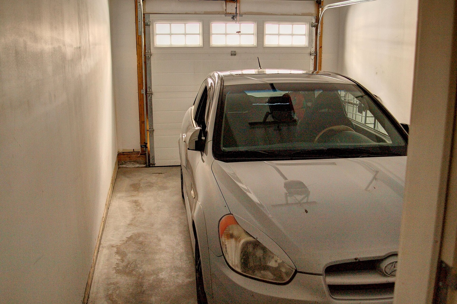 Licensed representative photograph of a car inside a townhouse garage in Calgary, used for a Penticton parking buyer guide and not depicting a specific property